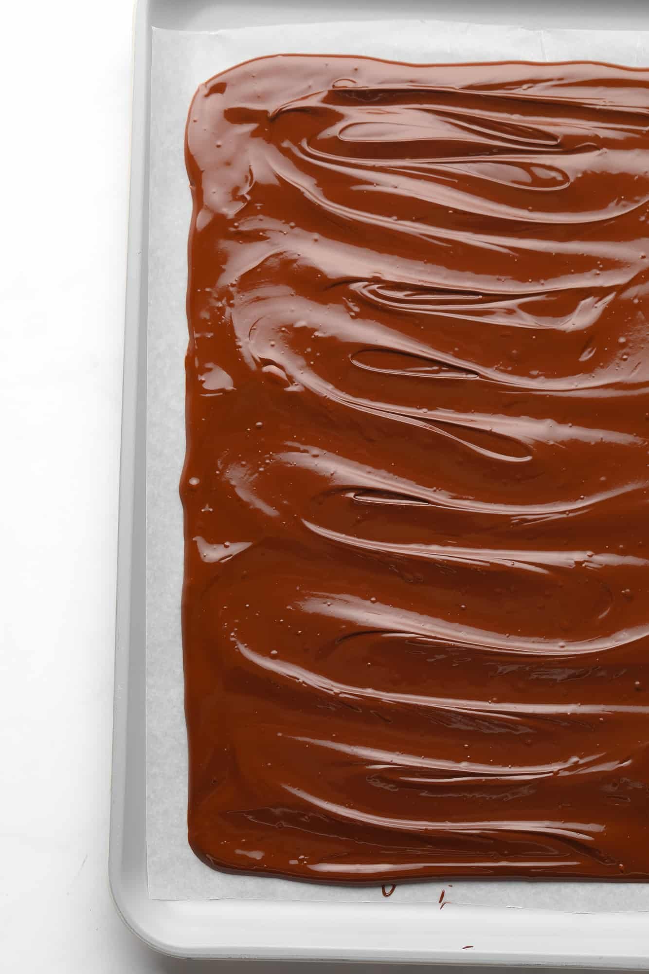 melted chocolate spread into a rectangle on a parchment-lined baking sheet.