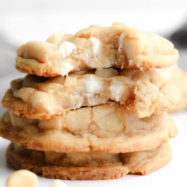 a stack of Vegan White Chocolate Macadamia Nut Cookies with bites taken out of them.