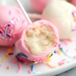 close up of a pink vanilla vegan cake pop with a bite taken out of it.