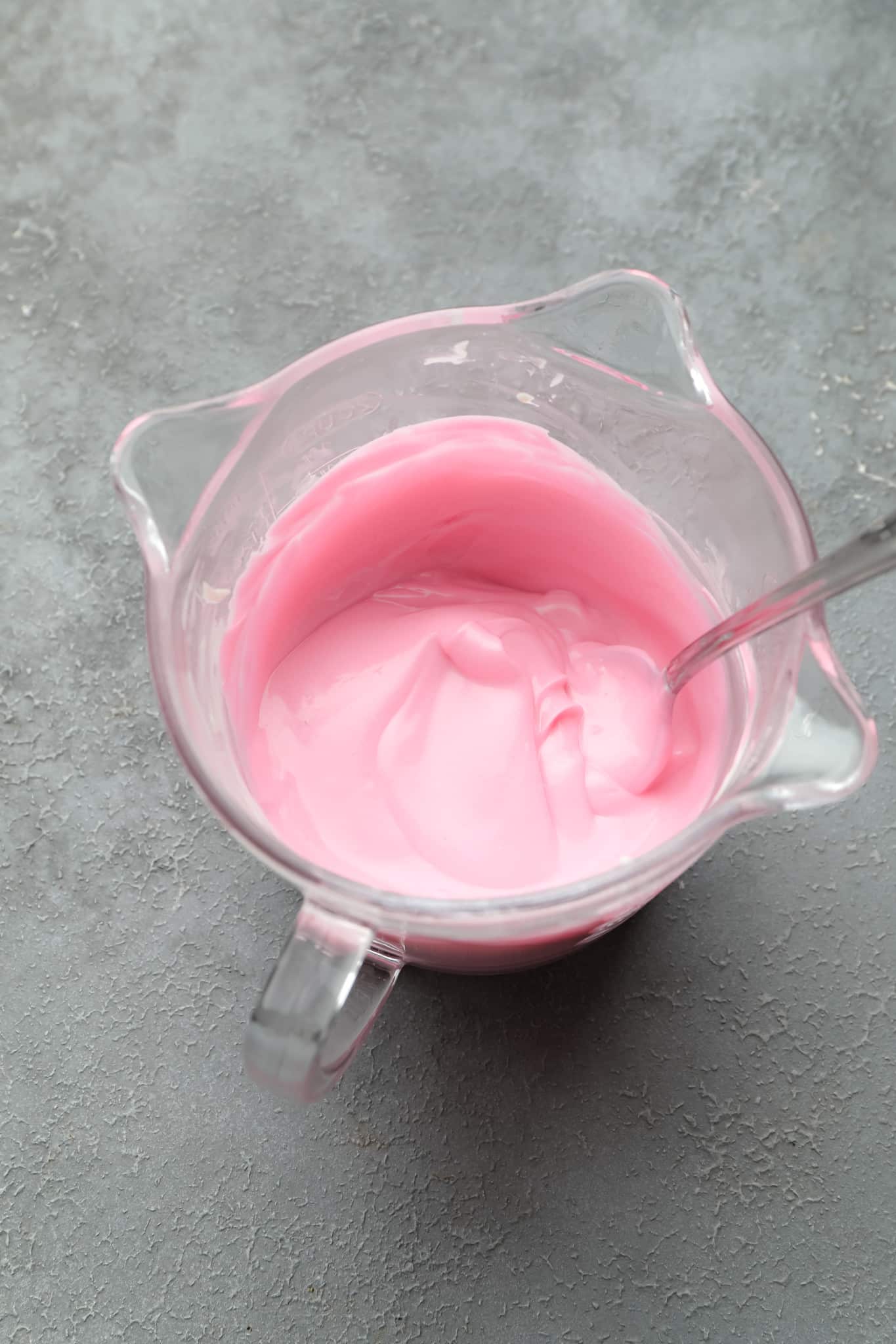 melted pink chocolate in a glass measuring cup.