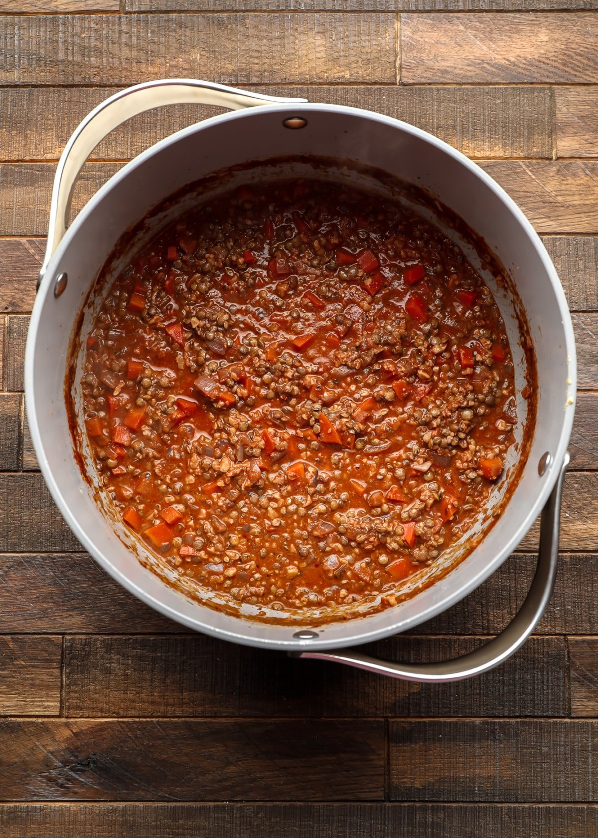 lentils and carrots in a reddish sauce in a pot