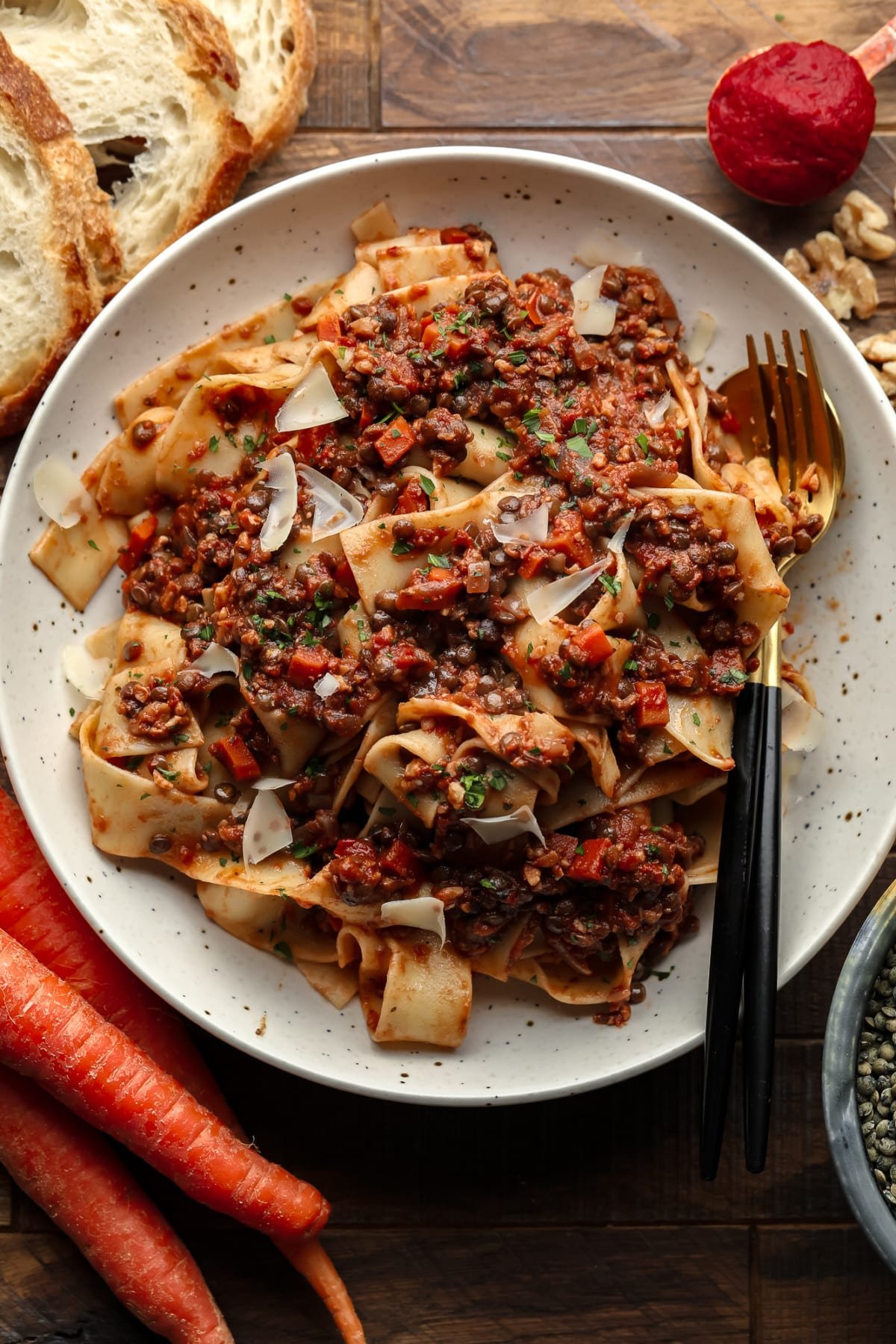 bowl with pasta and lentils, bread, carrots and lentils around it