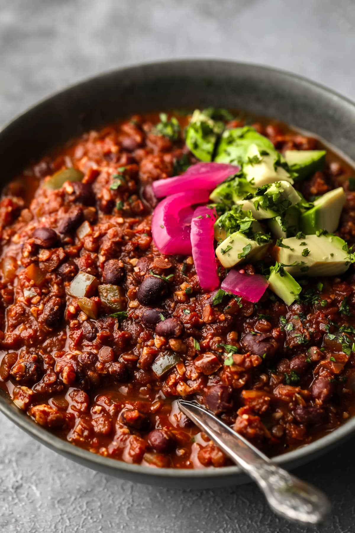 grey bowl with chili, pickled onions and avocado