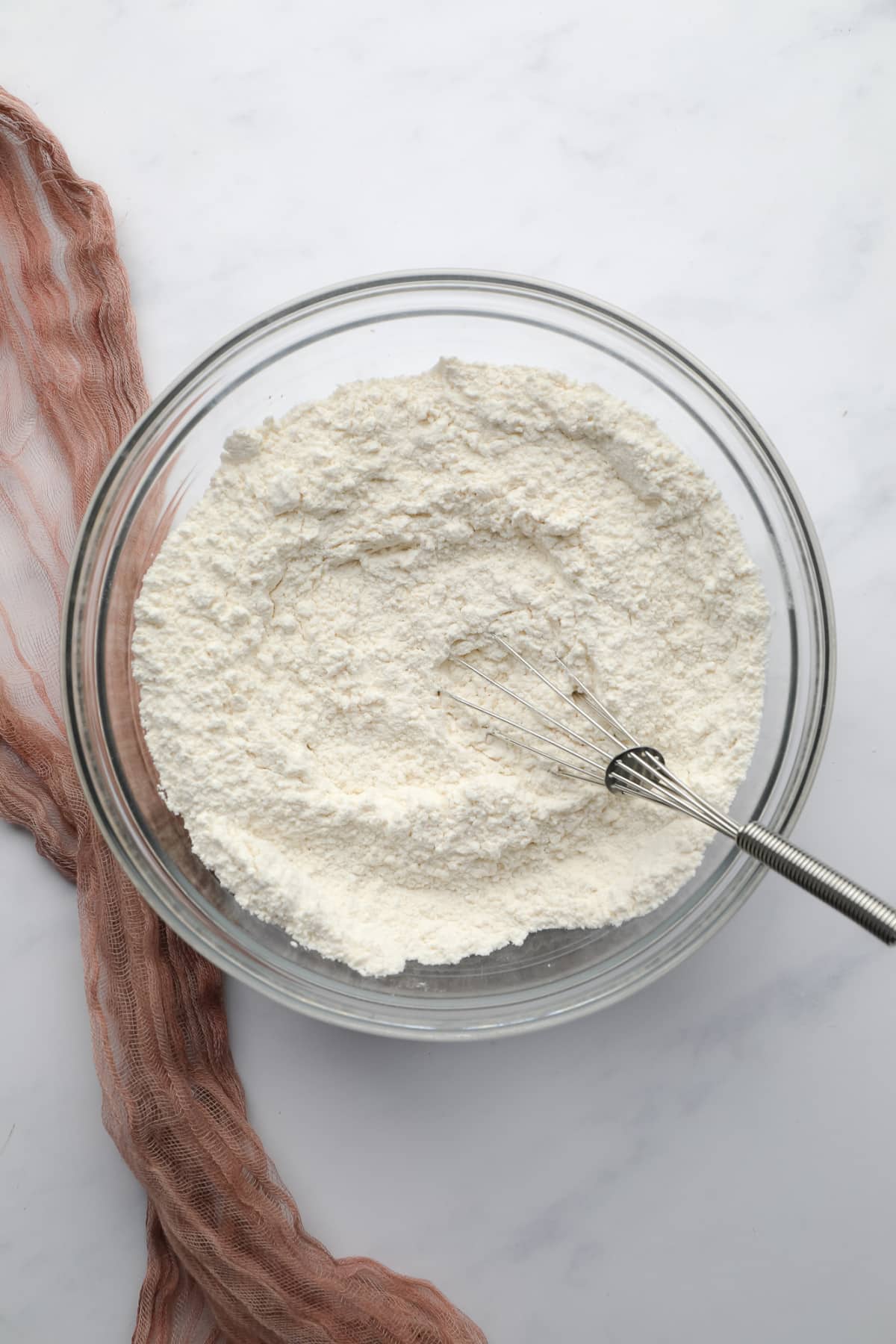 bowl of flour with a whisk