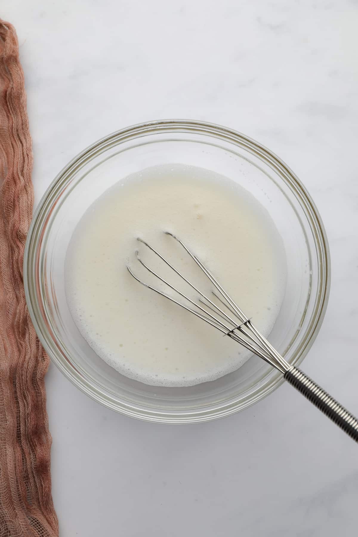 bowl with whipped foam and a whisk