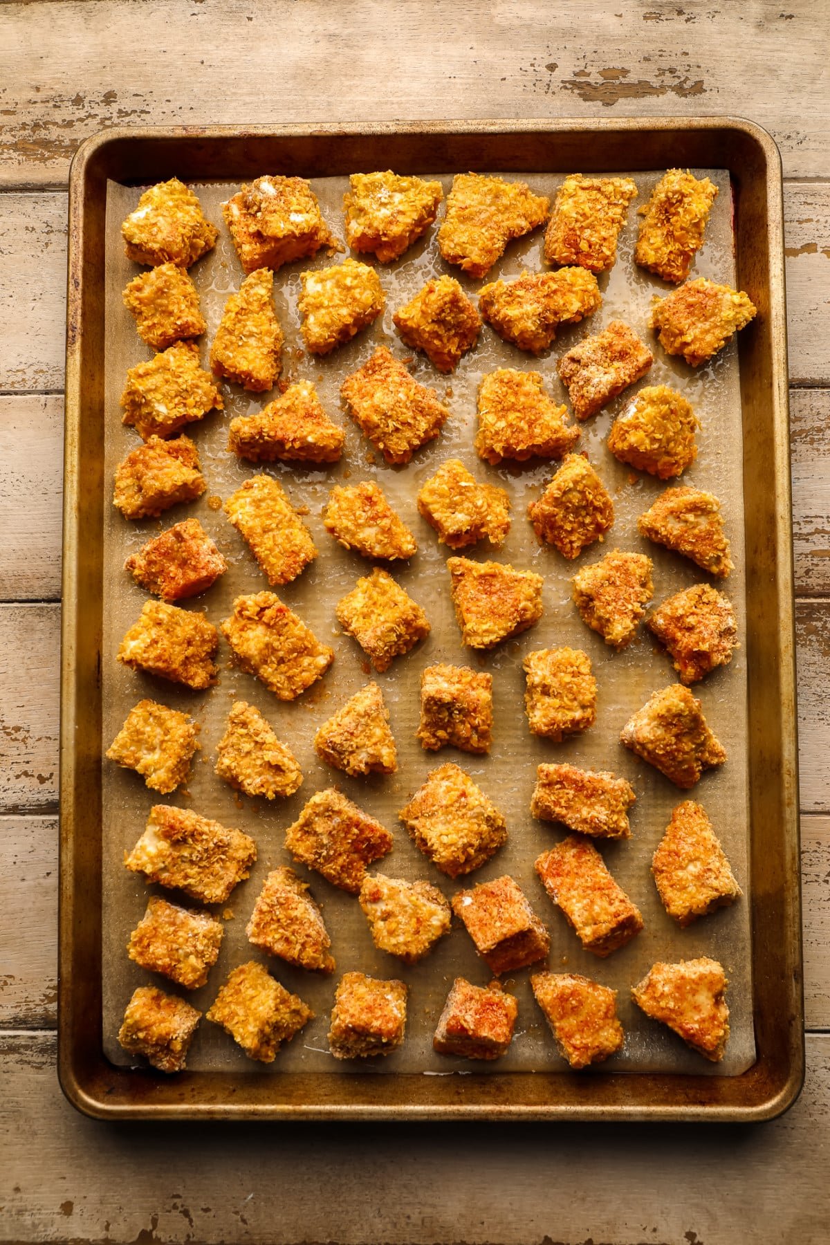 crispy tofu chunks on a gold pan on wooden background