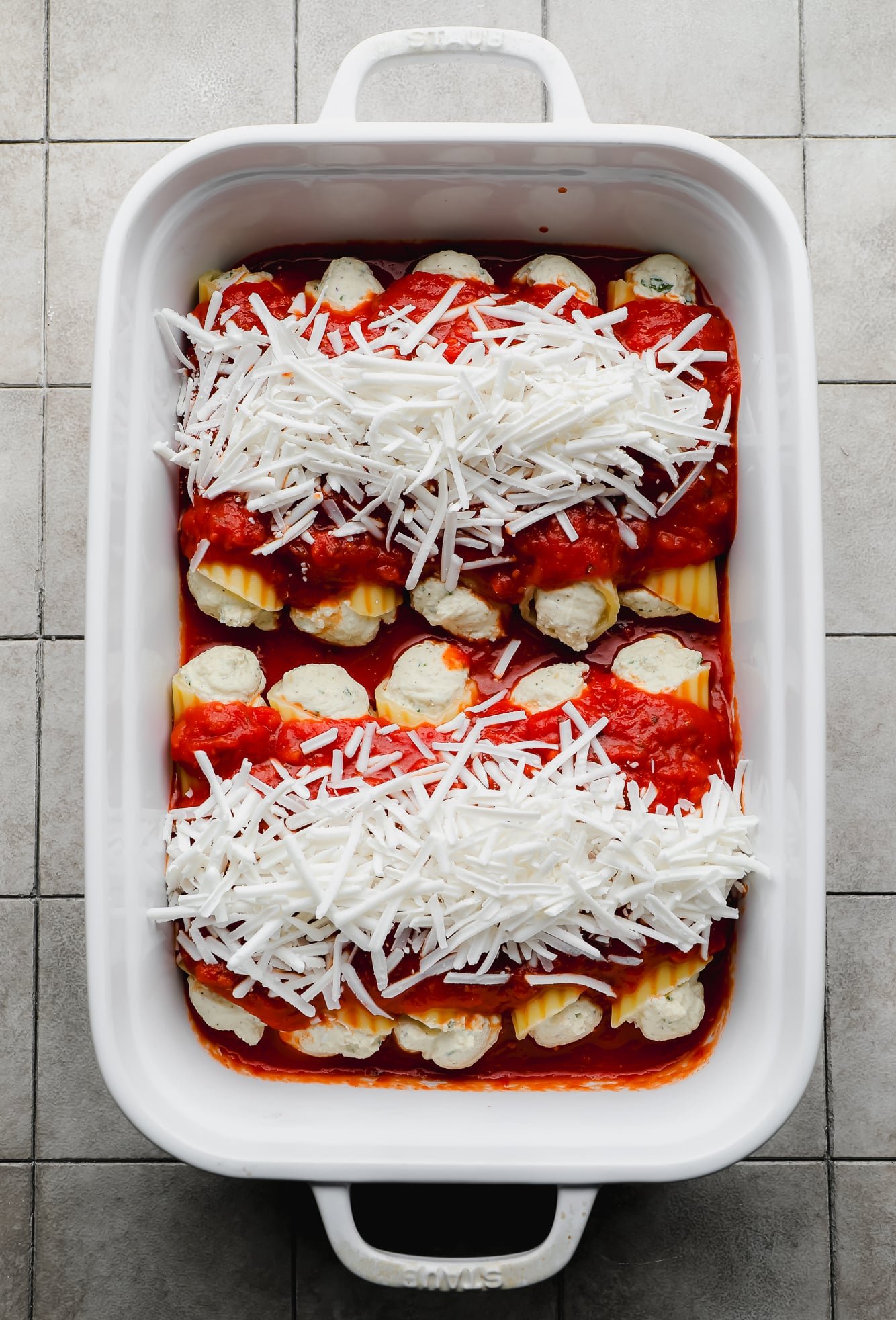assembled and unbaked Vegan Manicotti in a white baking dish.