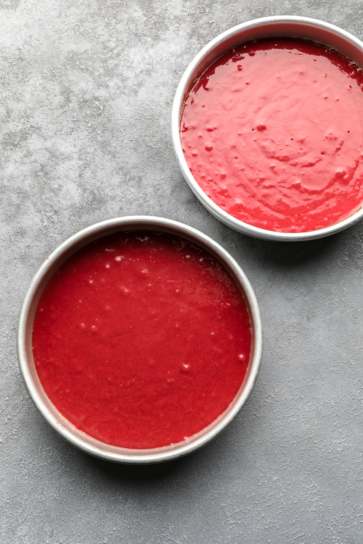 red cake batter in round pans