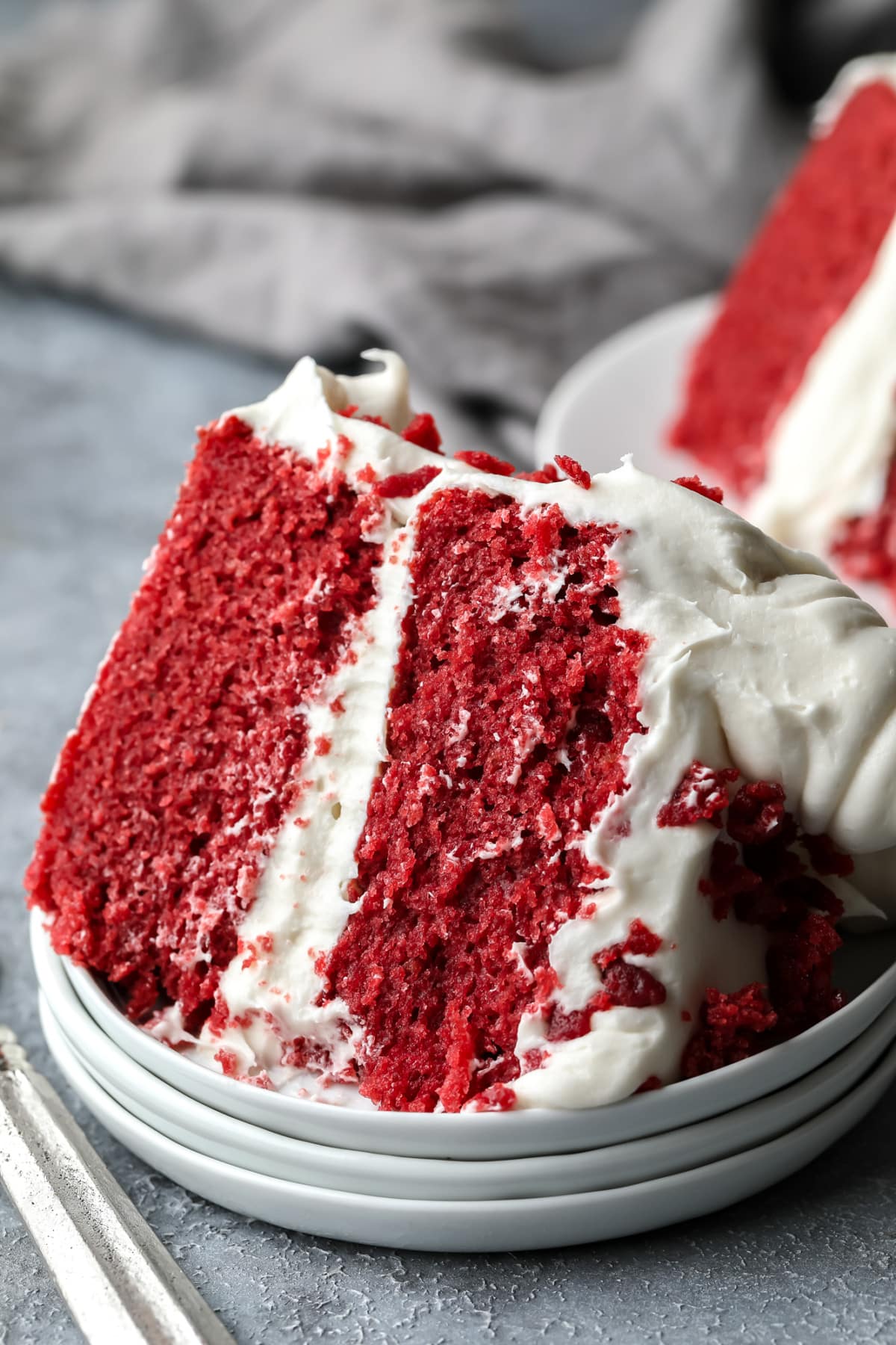 piece of red cake and white frosting on triple plate