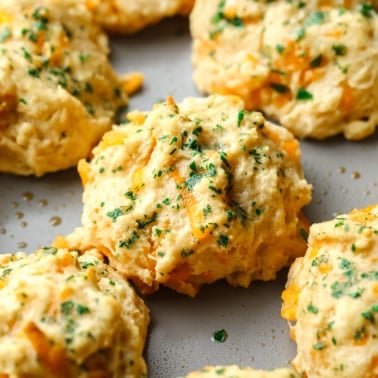 close up on vegan cheddar bay biscuits topped with parsley.
