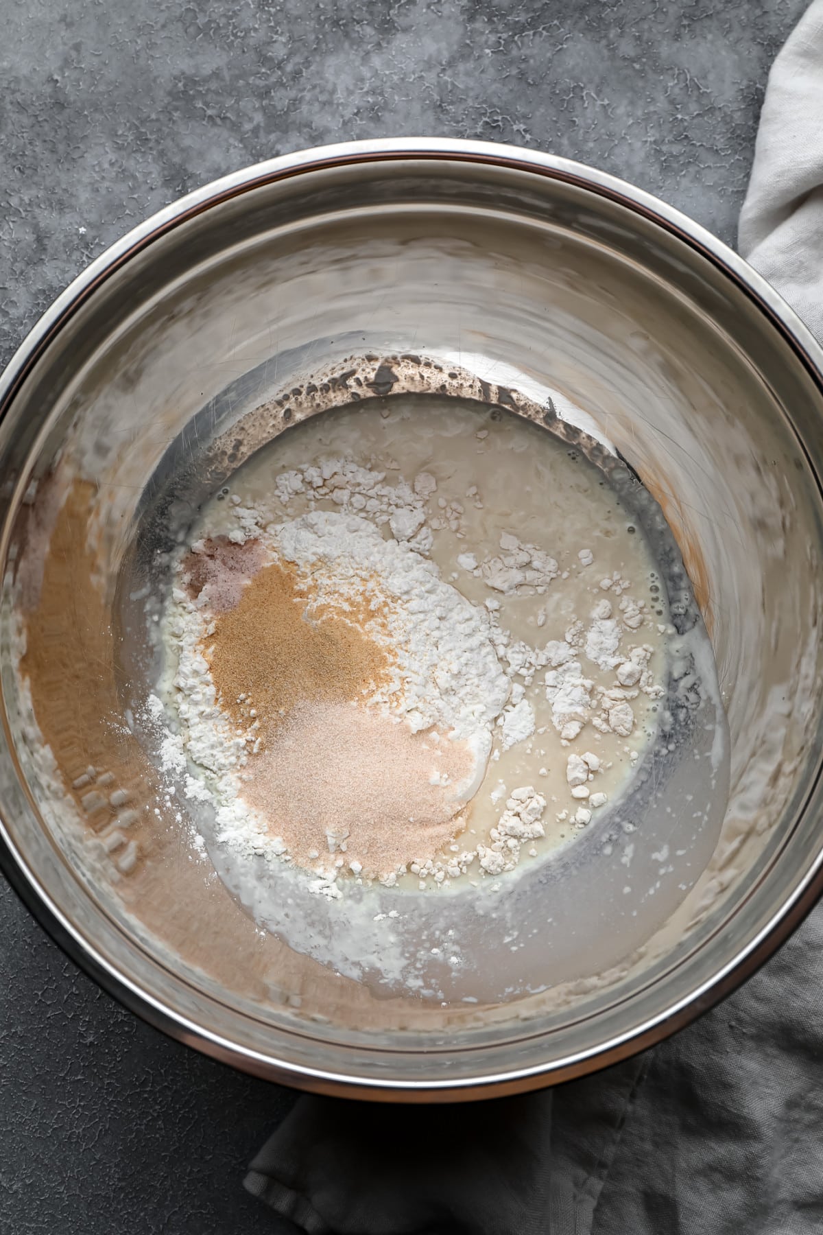 silver bowl with flour and spices and milk in it, not mixed