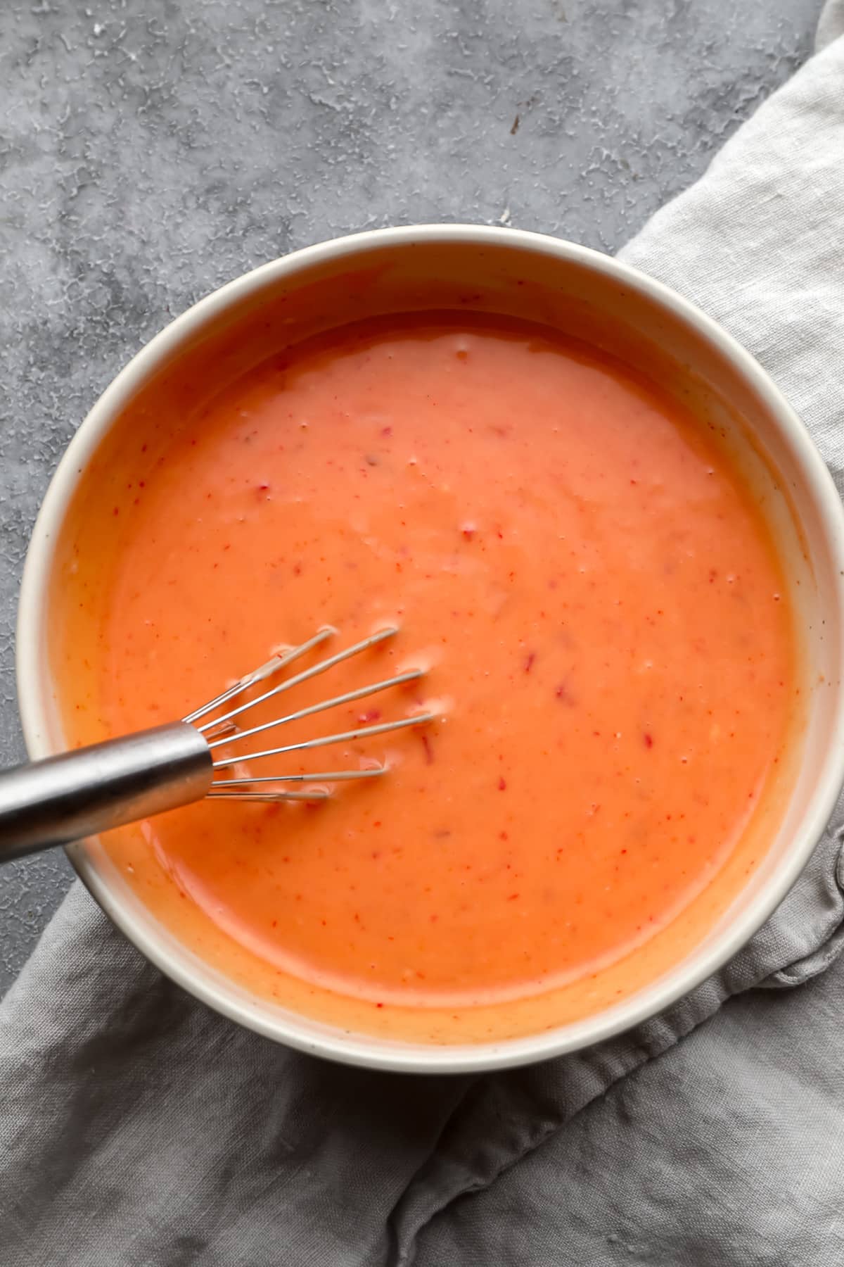 mixed bang bang sauce in a bowl with a whisk