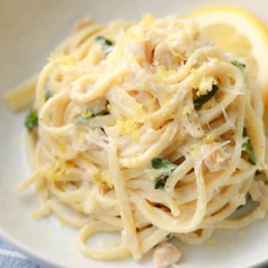 close up on creamy lemon pasta in a white bowl.