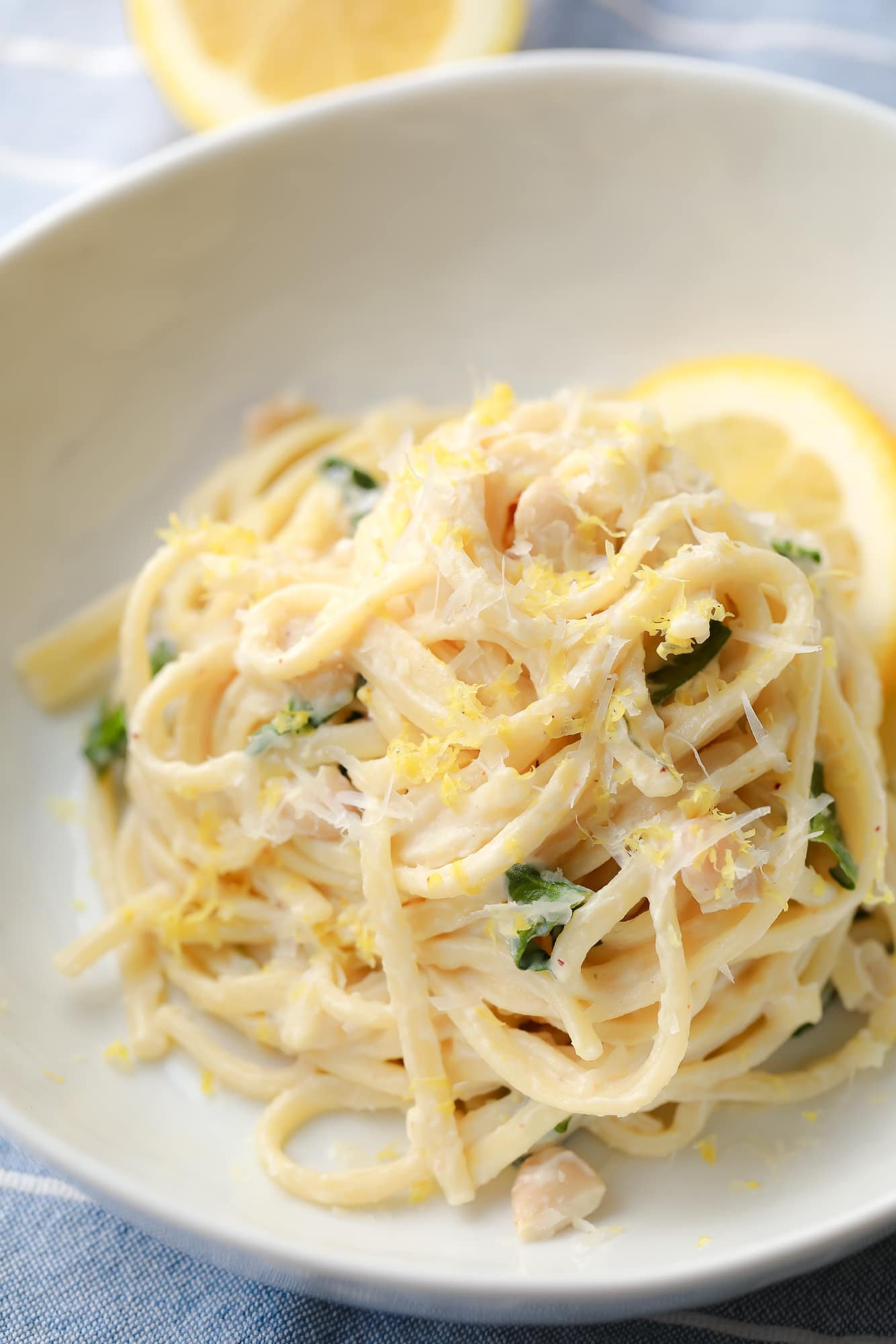 close up on creamy lemon pasta in a white bowl.