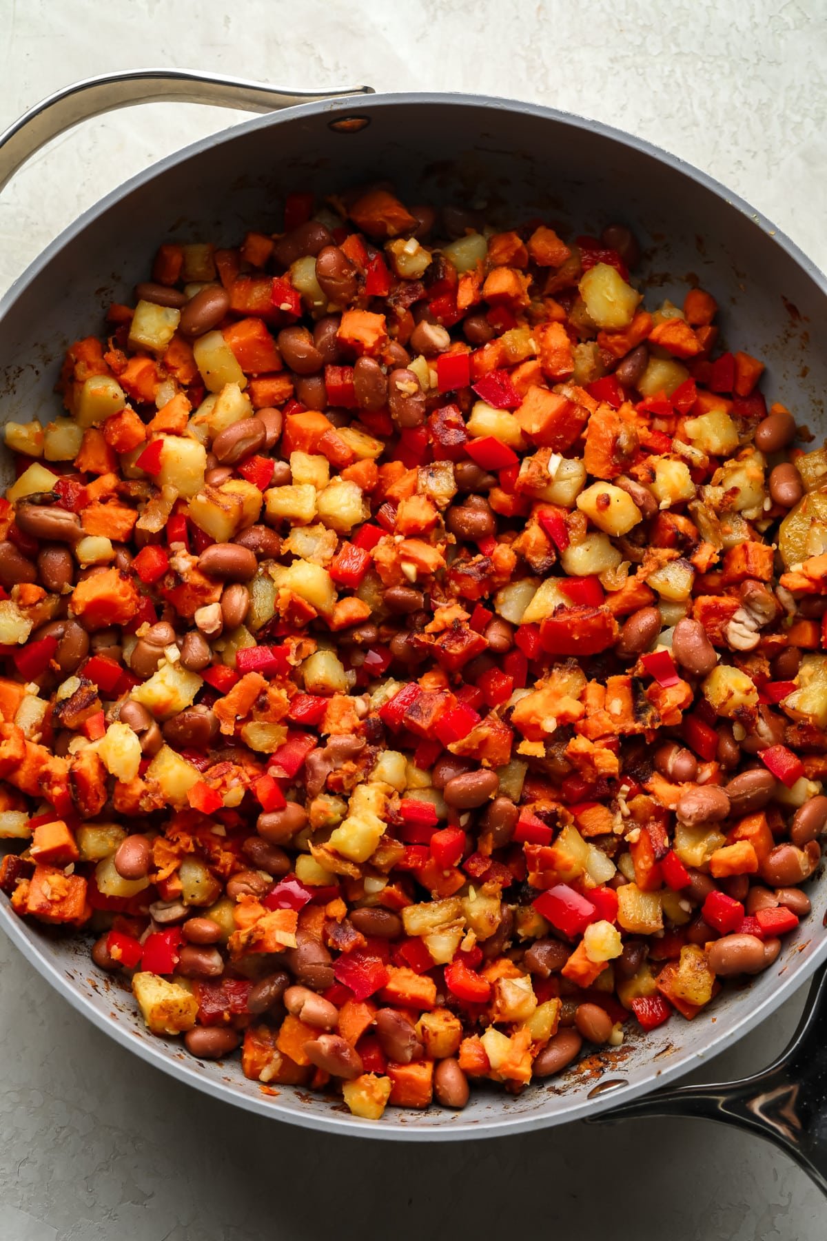 breakfast hash in pan with sweet and regular potatoes, red pepper and beans