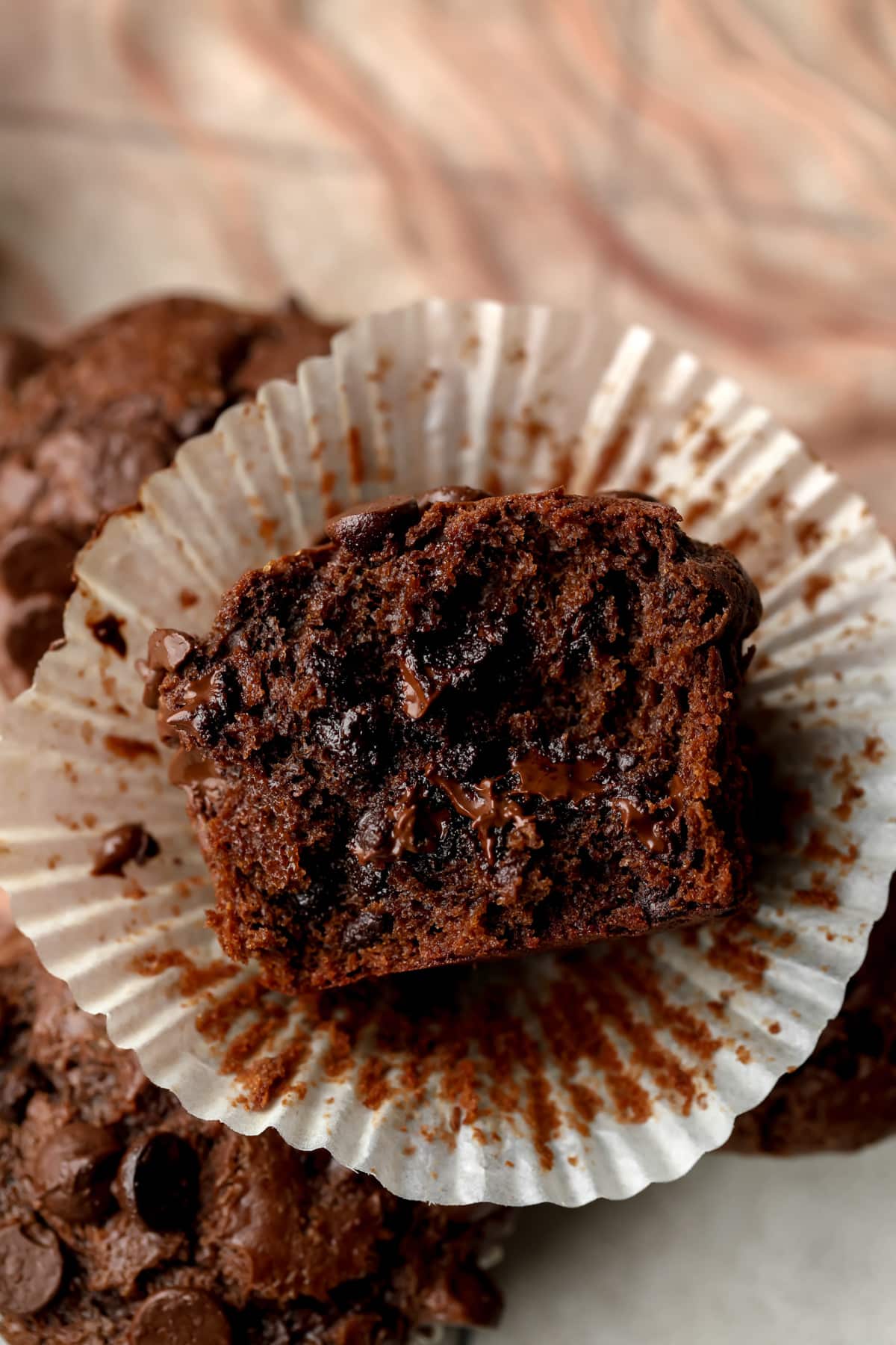 showing cut in half vegan chocolate muffin, showing gooey chocolate inside