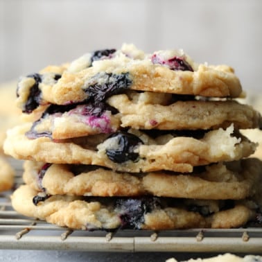 stack of blueberry cookies on cooling rack with gray background