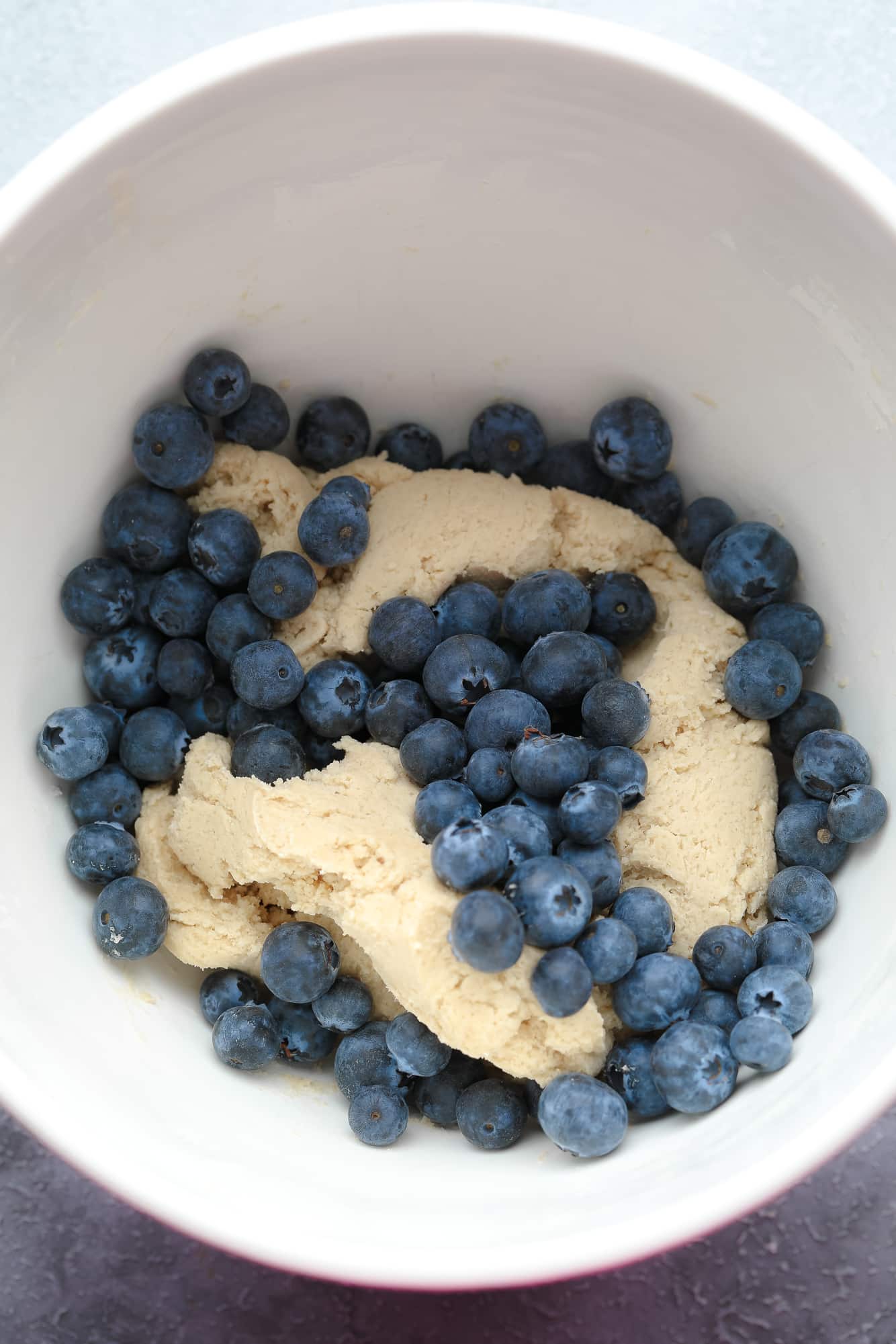 cookie dough and fresh blueberries in a large white bowl.