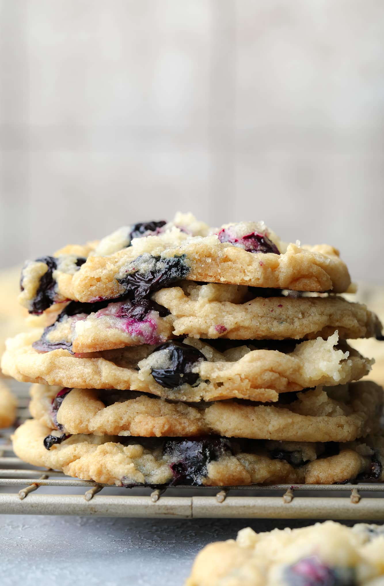a stack of vegan blueberry cookies on a wire rack.