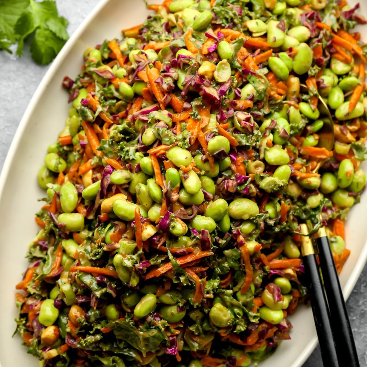 a large batch of Edamame Salad with Peanut Sauce on a white serving platter.