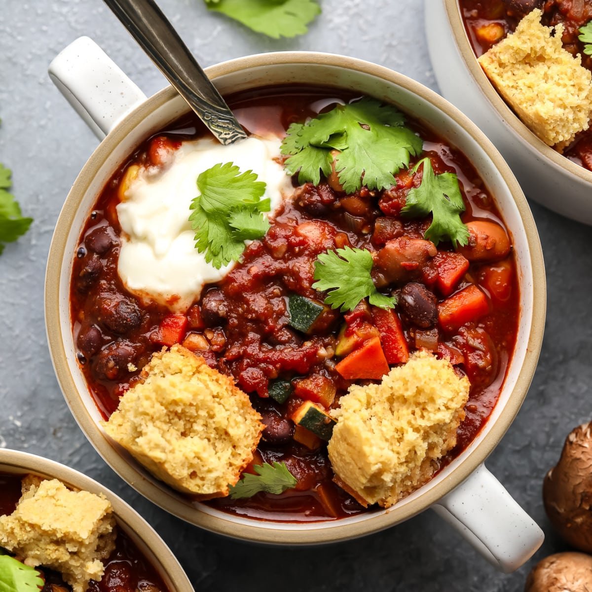 a small bowl of veggie chili topped with vegan cornbread.