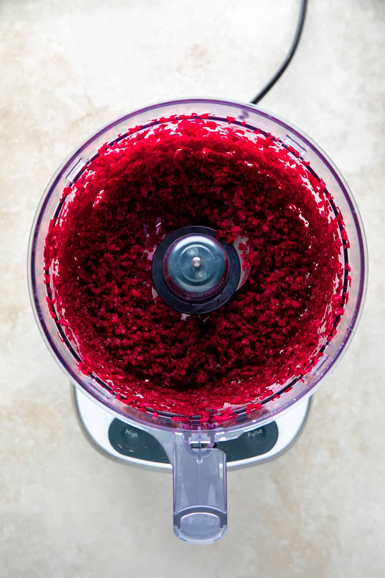 shredded red beets in a food processor.