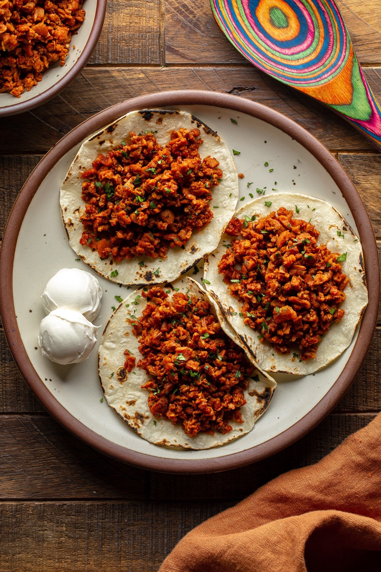 three tortillas topped with vegan chorizo on a plate.