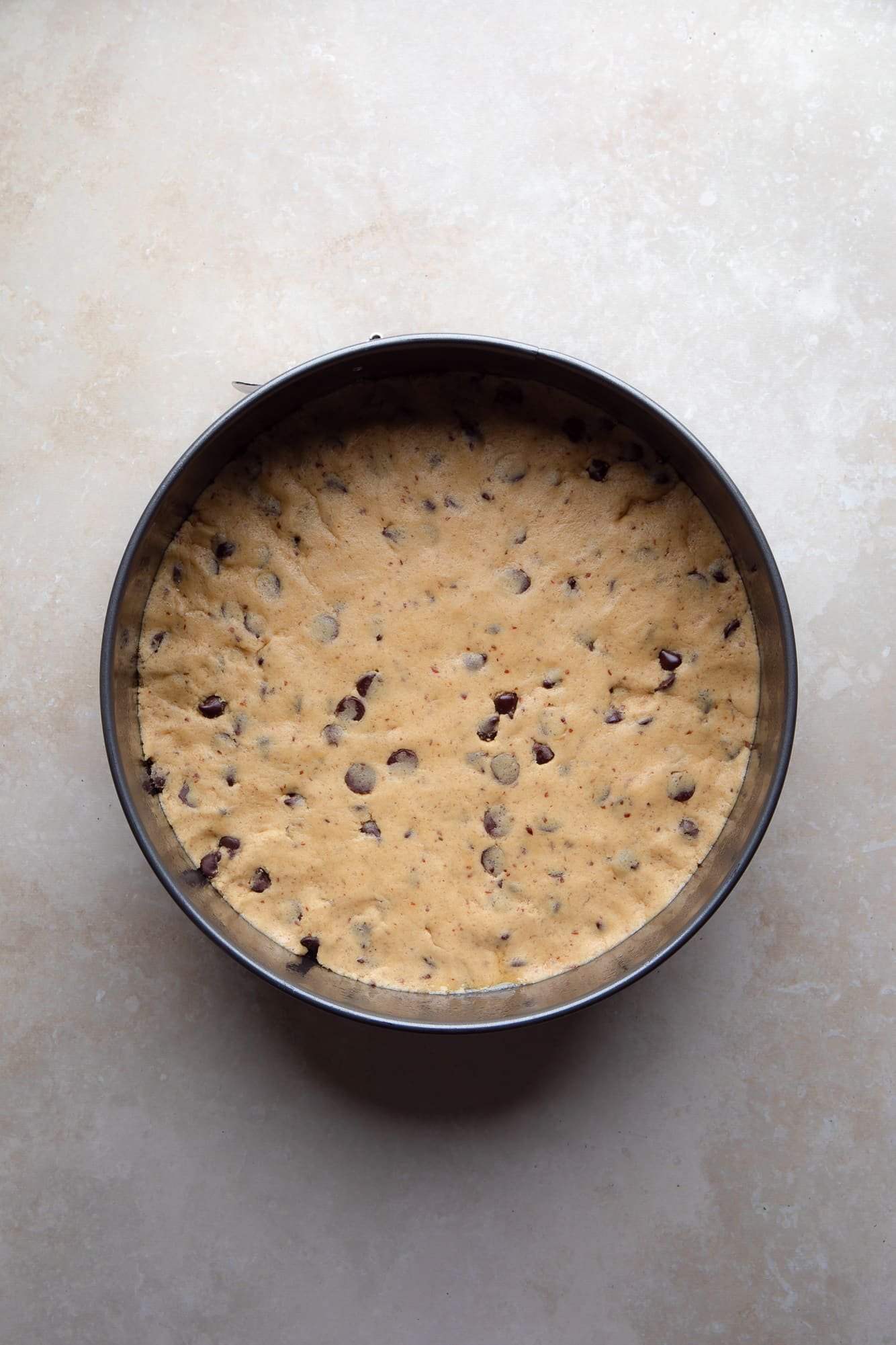 overhead view of an unbaked vegan cookie cake in a cake pan.