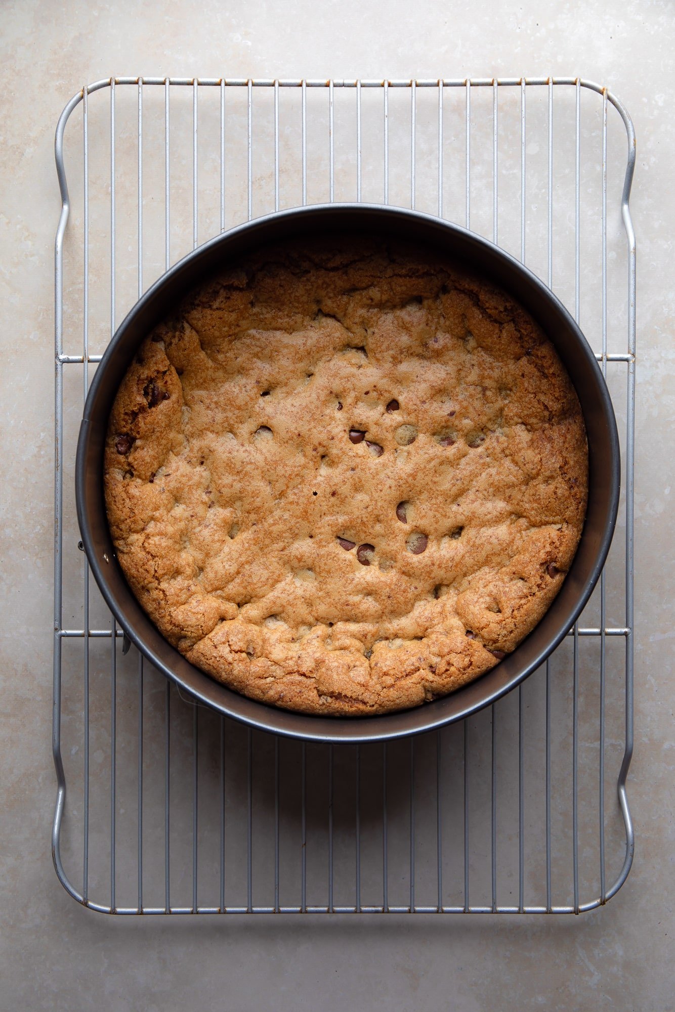 overhead view of a baked vegan cookie cake in a cake pan.
