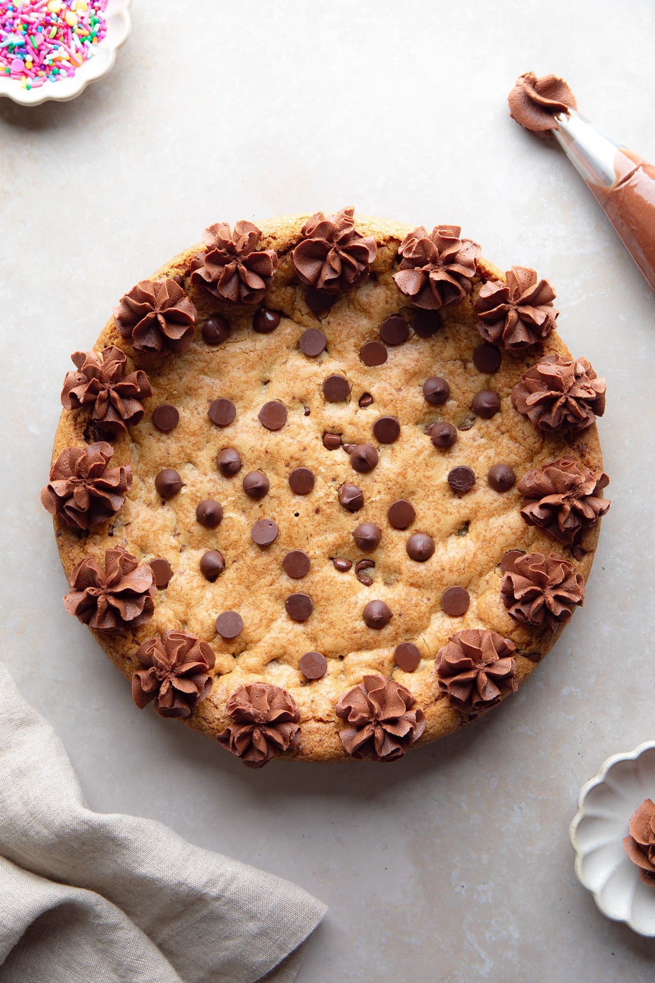 overhead view of a vegan cookie cake decorated with piped chocolate frosting.