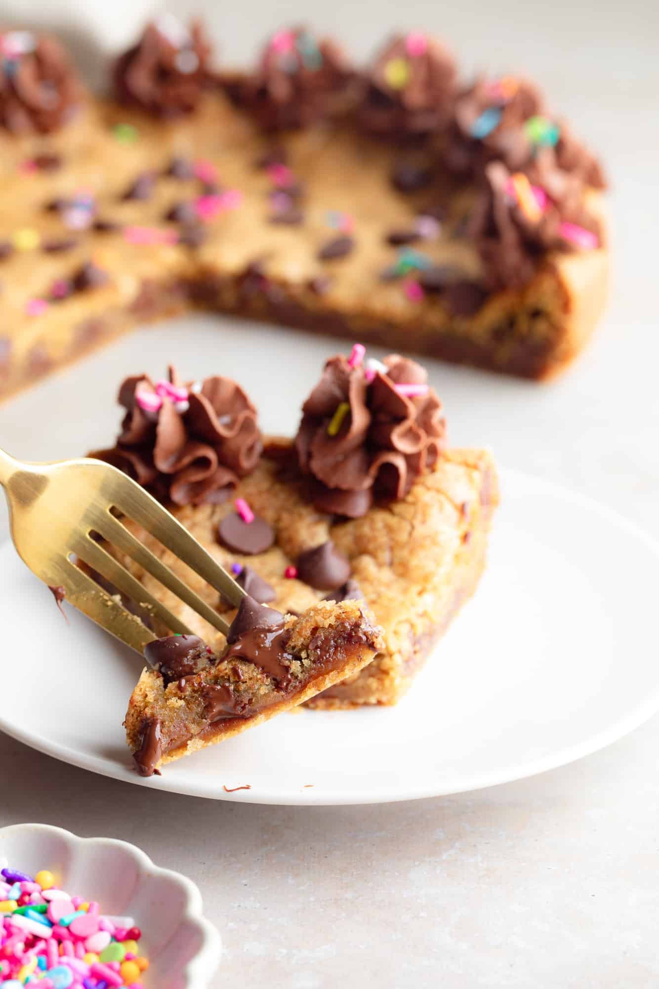 close up on a fork holding a bite of a vegan cookie cake.