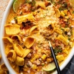close up on a black spoon in a batch of vegan Mexican street corn dip in a baking dish.