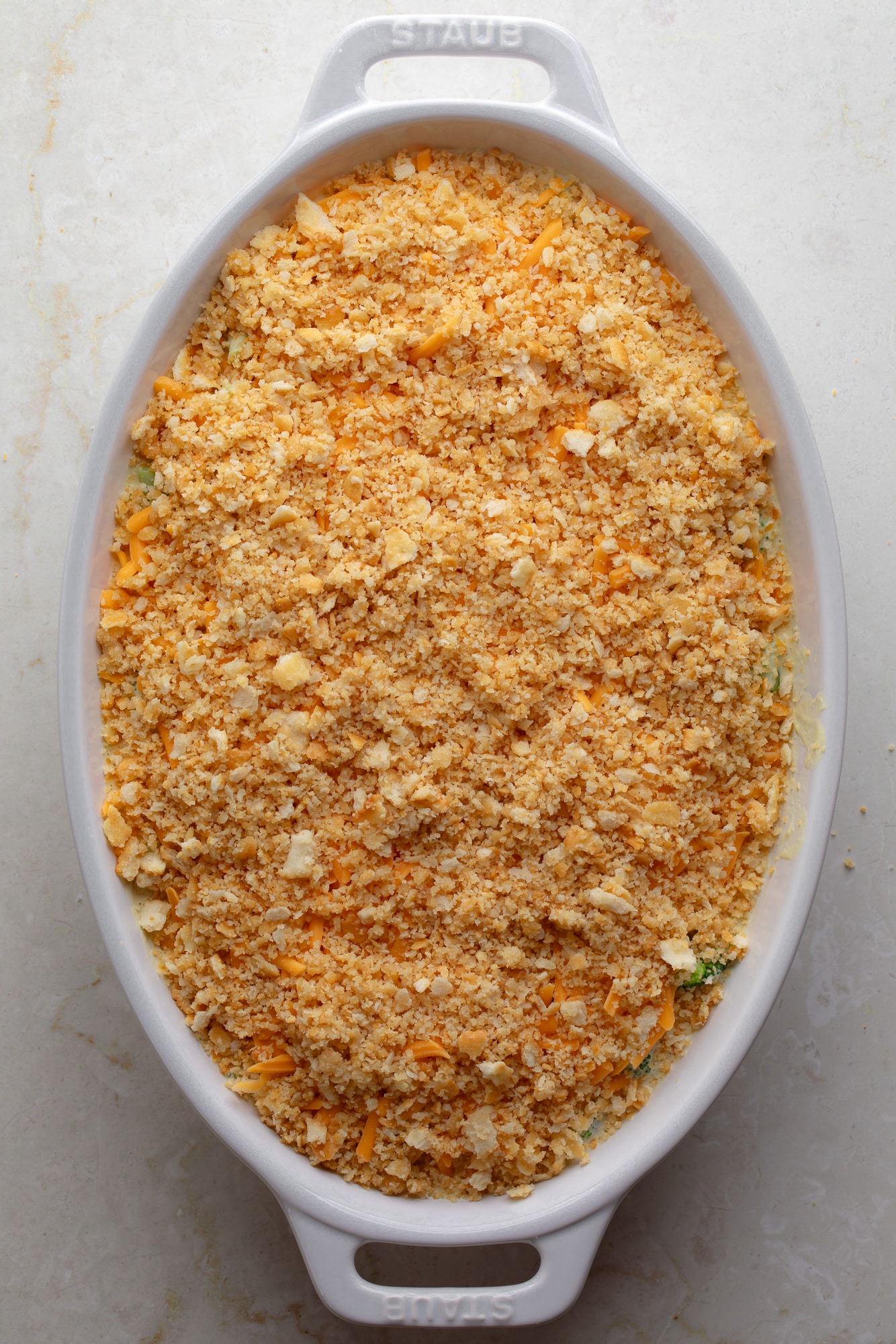 overhead view of a cracker crumb-topped vegan broccoli casserole in a large casserole dish.