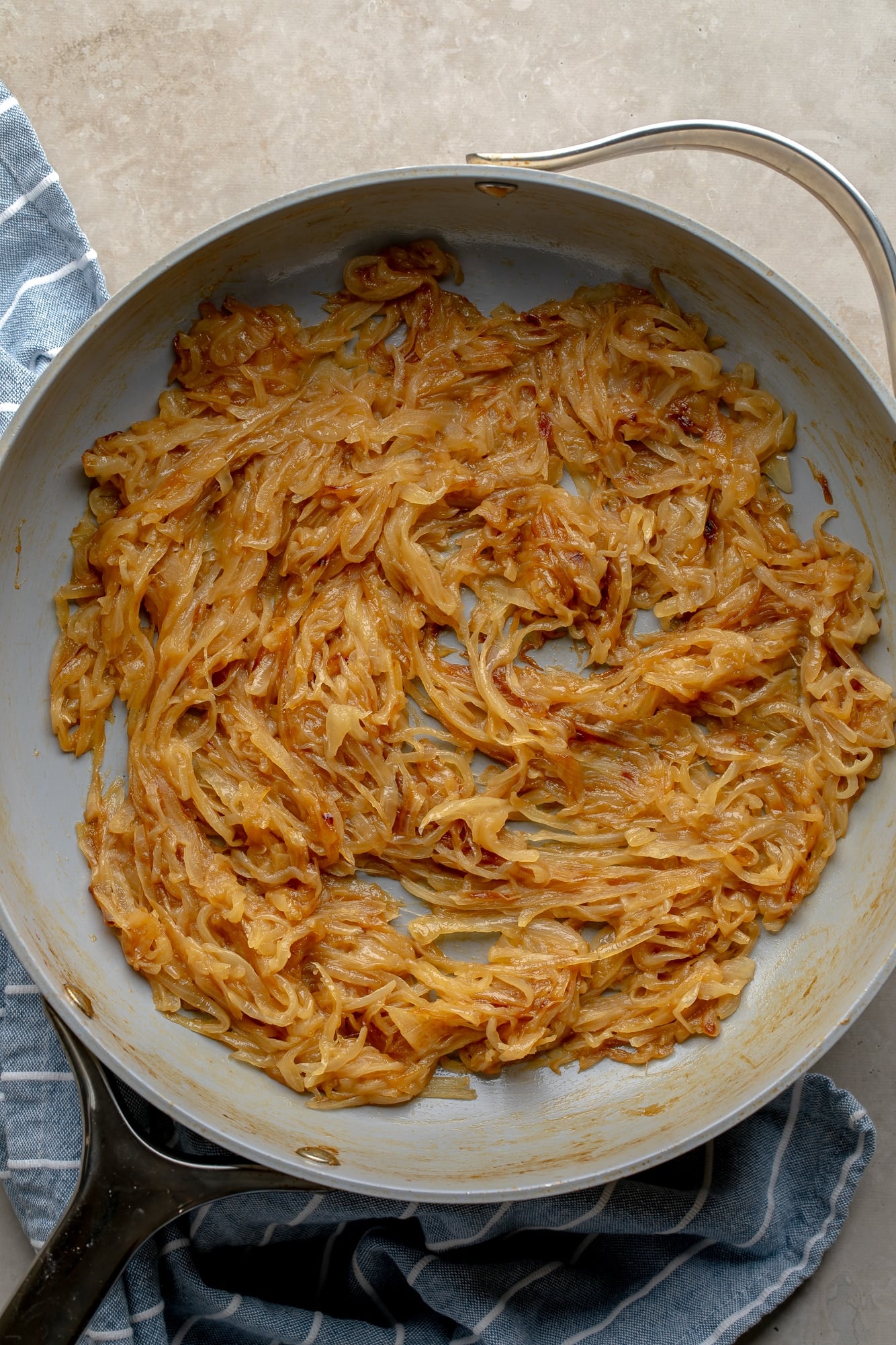 overhead view of caramelized onions in a large skillet.