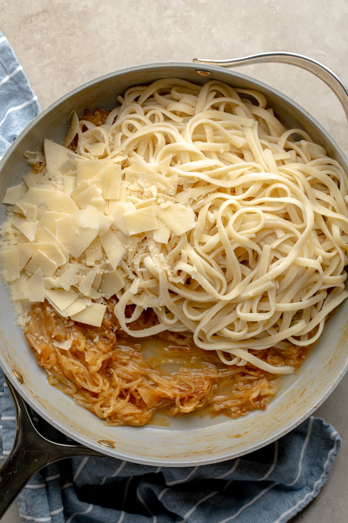 overhead view of a skillet full of the ingredients for vegan caramelized onion pasta.