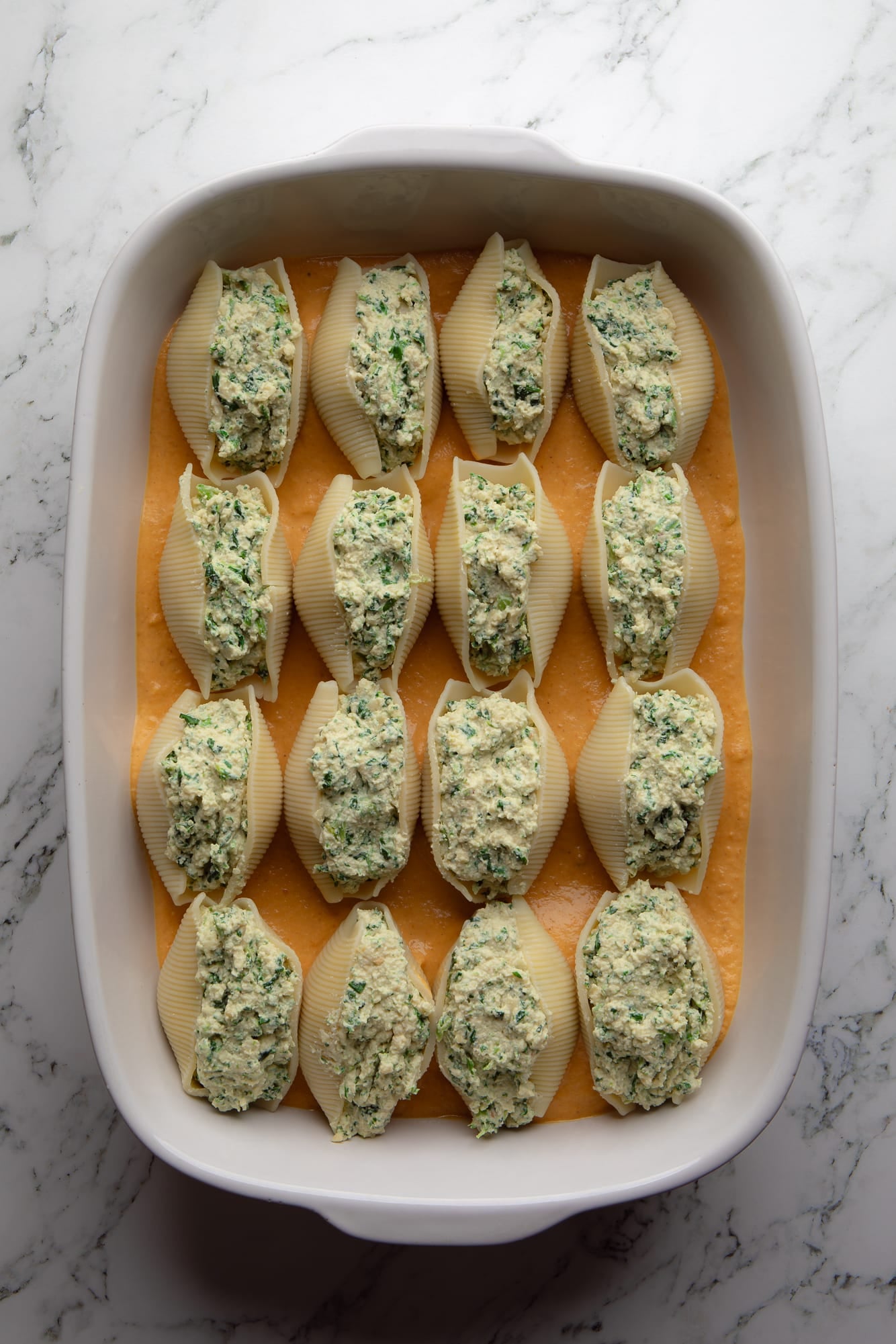 overhead view of assembled vegan pumpkin stuffed shells in a casserole dish.