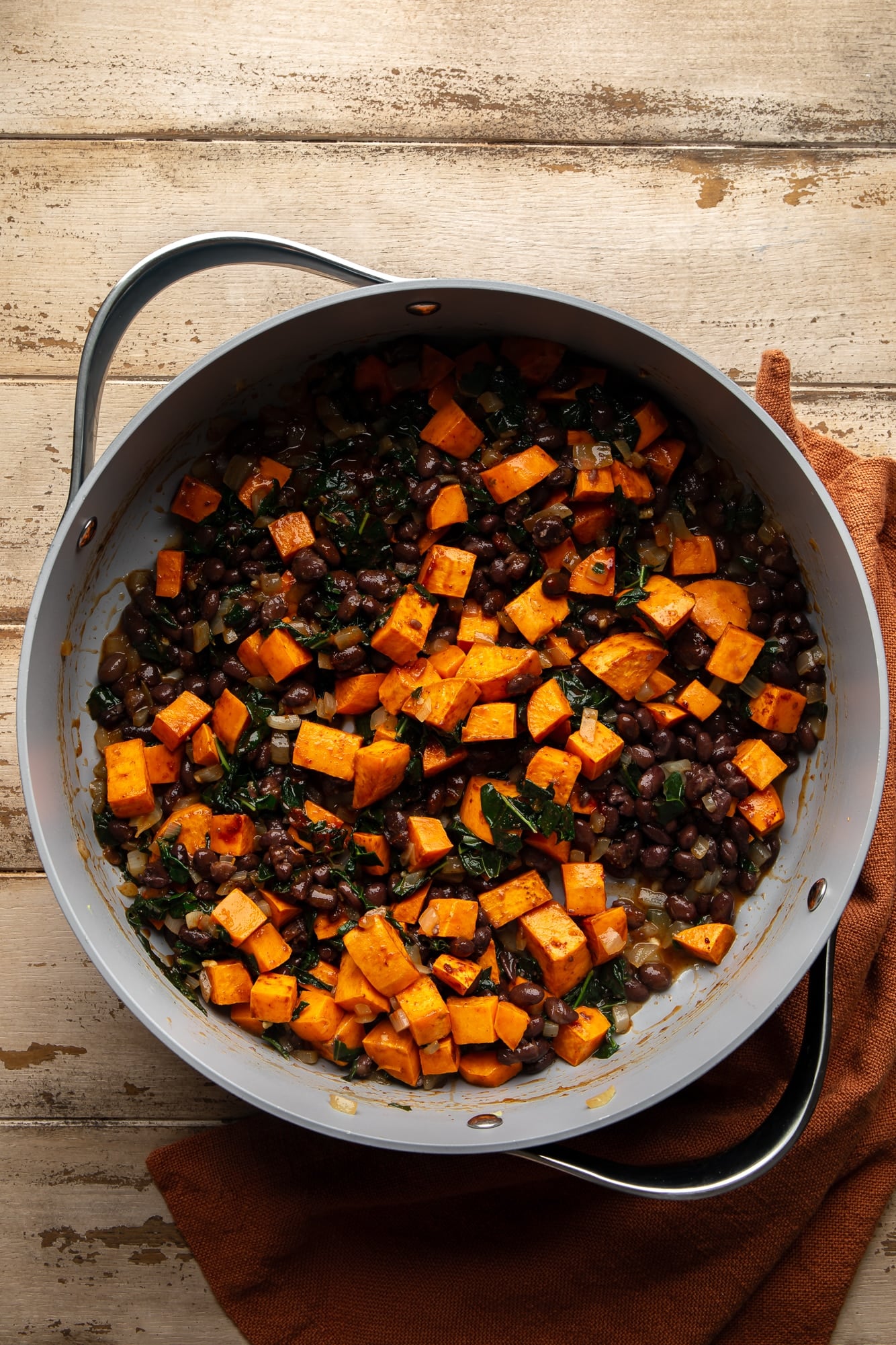 cooking sweet potatoes and black beans in a large pot.
