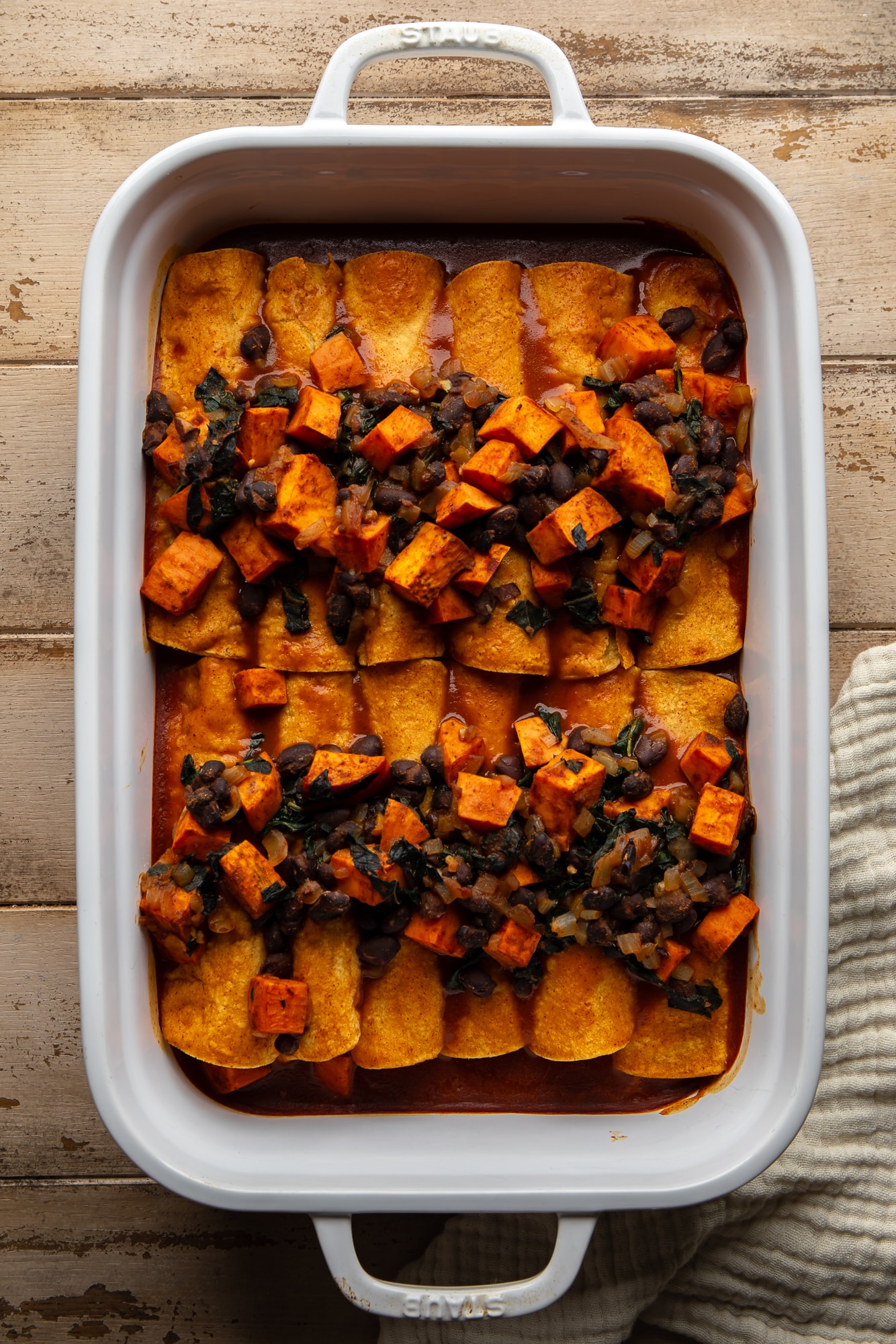 assembled sweet potato black bean enchiladas in a large casserole dish.