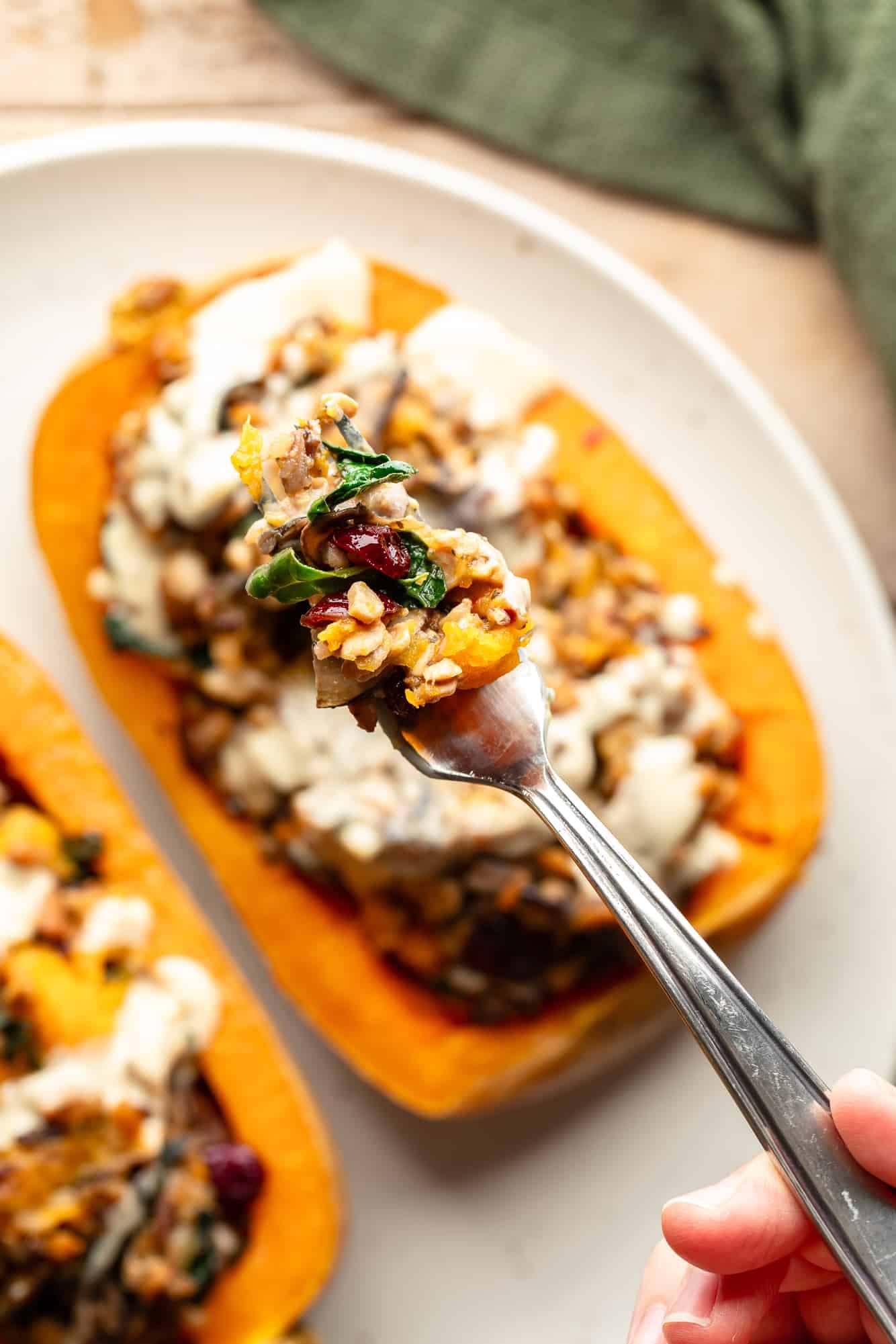 close up on a forkfull of stuffing taken from a stuffed butternut squash.