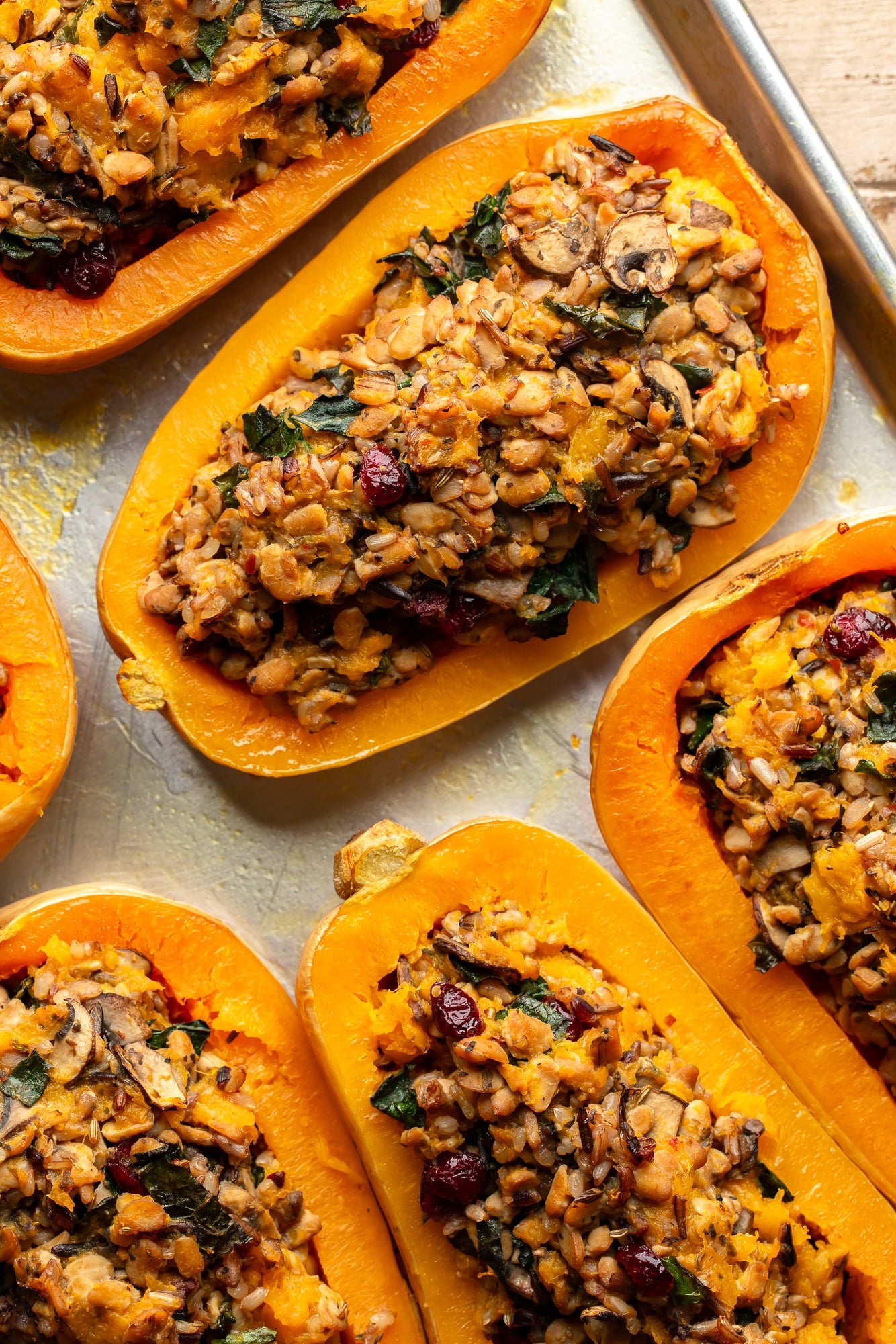 overhead view of stuffed butternut squashes on a baking sheet.