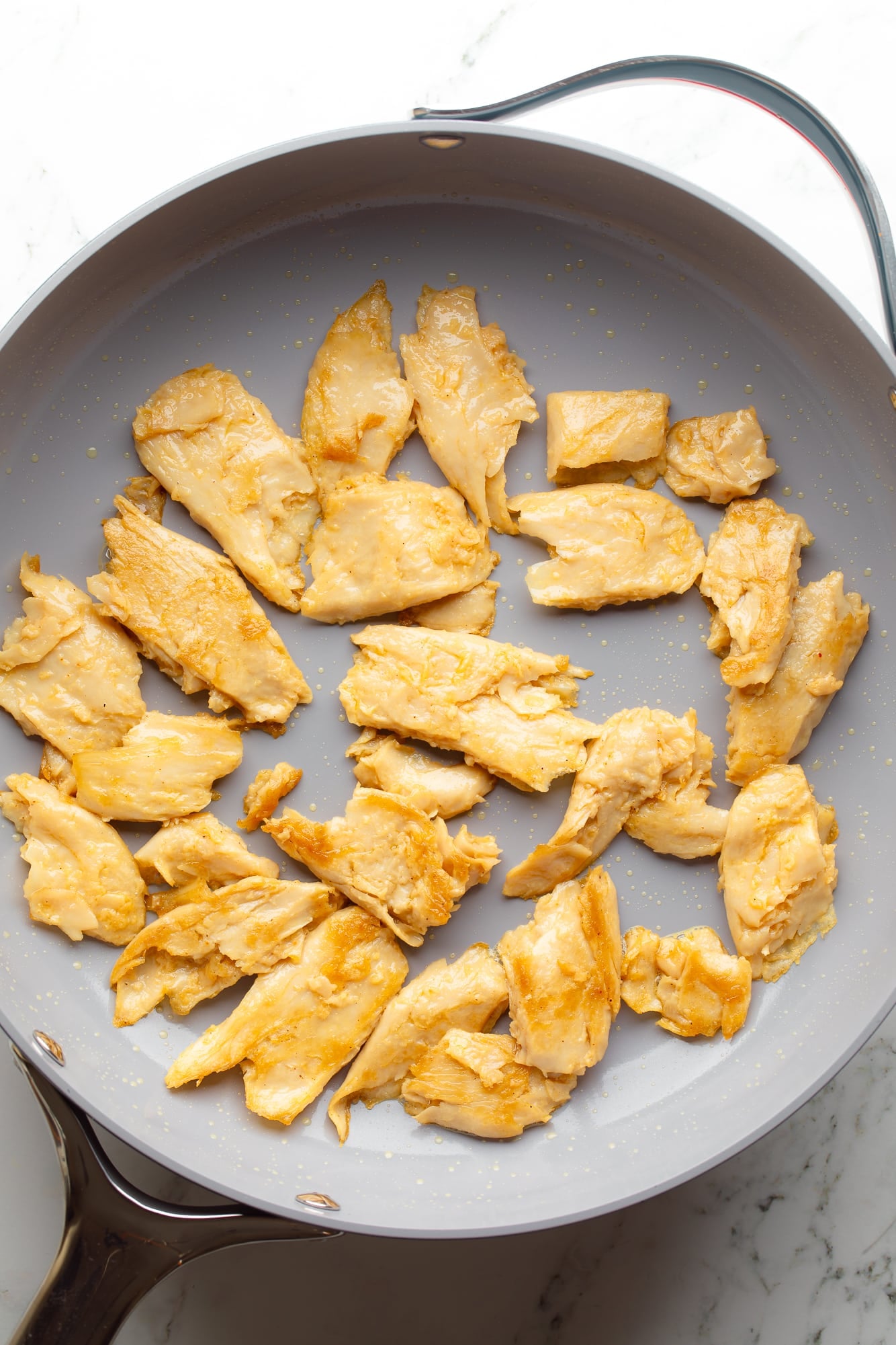 overhead view of cooked vegan chicken pieces for vegan marry me pasta in a large skillet.