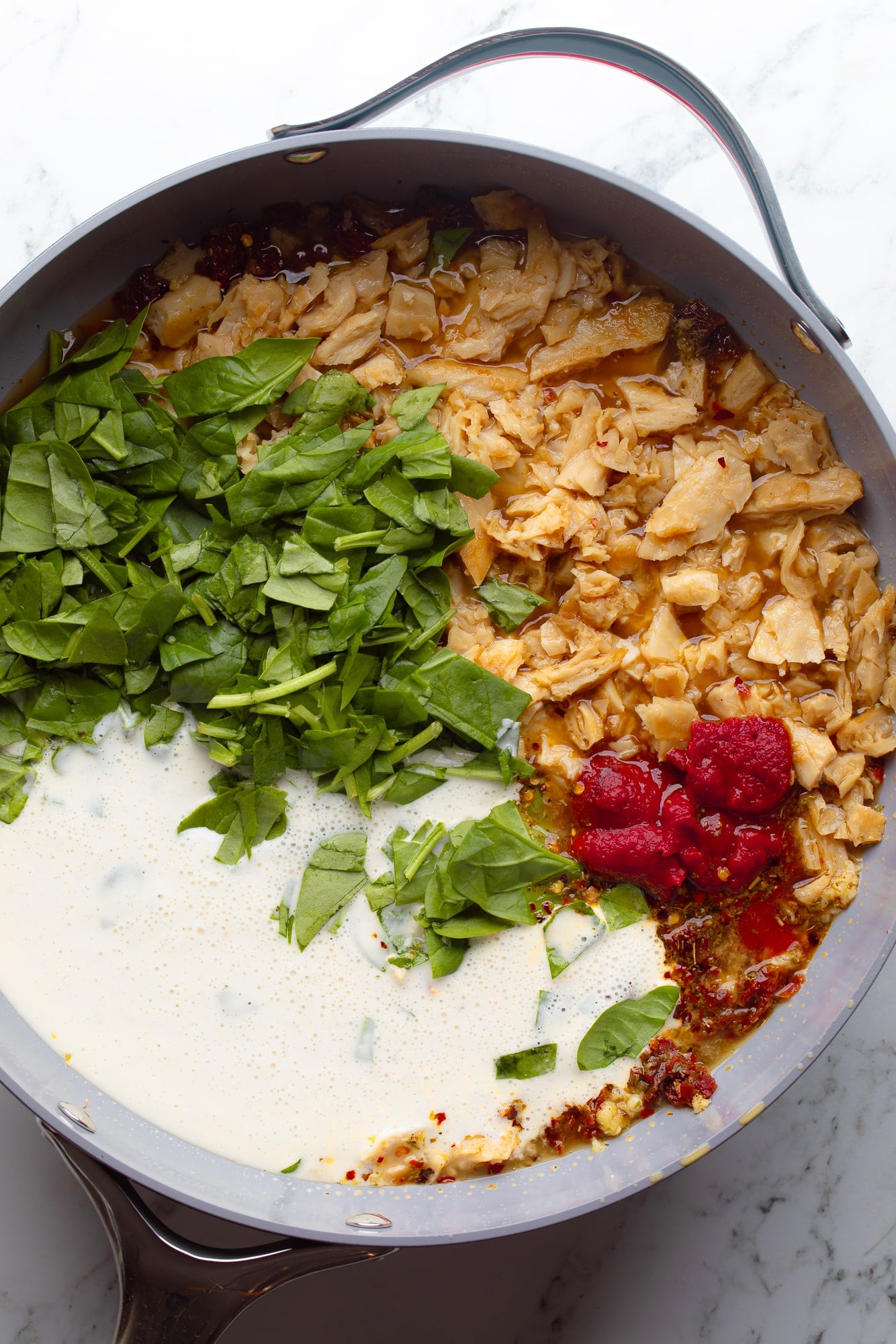 overhead view of the ingredients for vegan marry me pasta sauce in a large skillet.