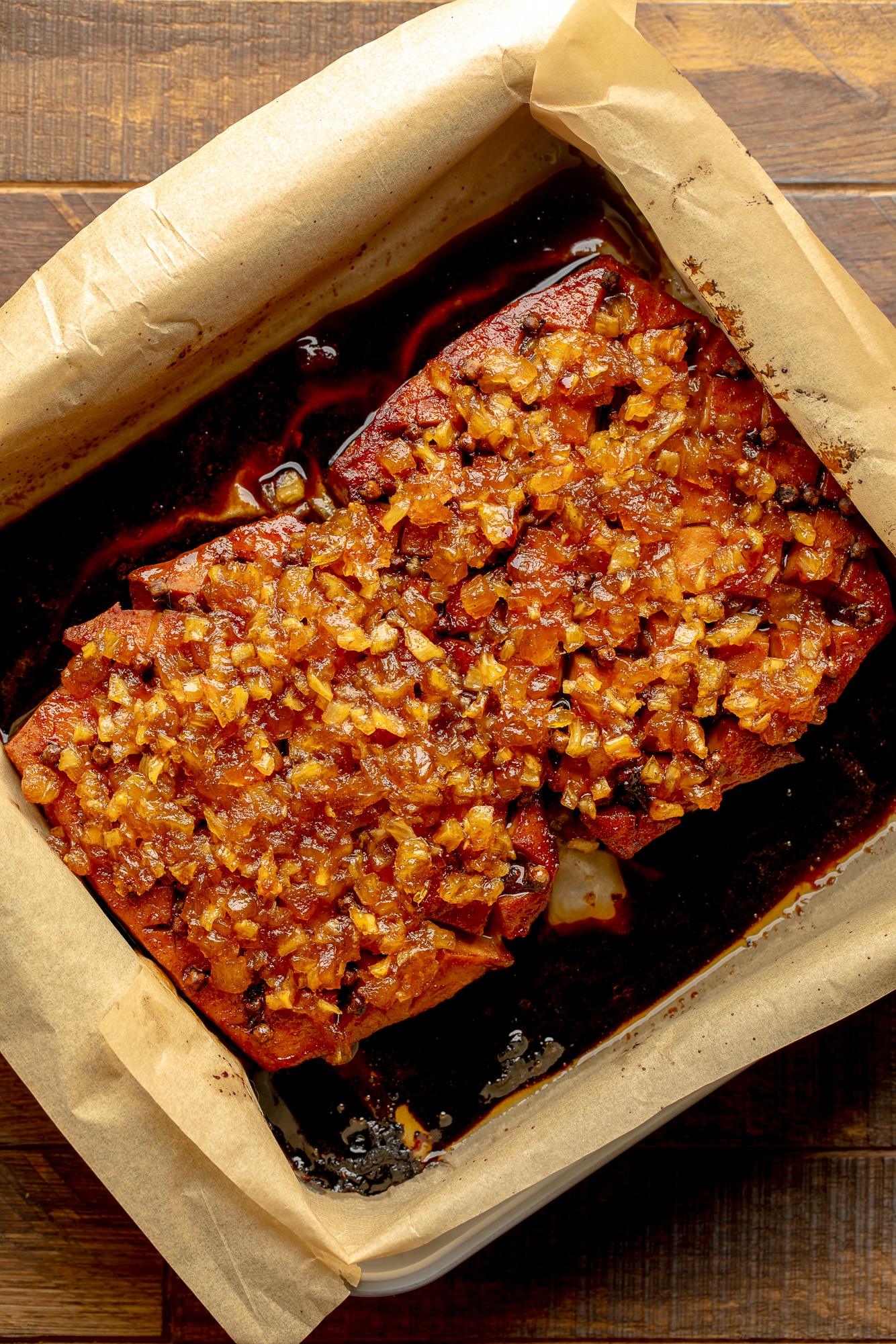overhead view of a pineapple glazed tofu roast in a parchment-lined baking dish.