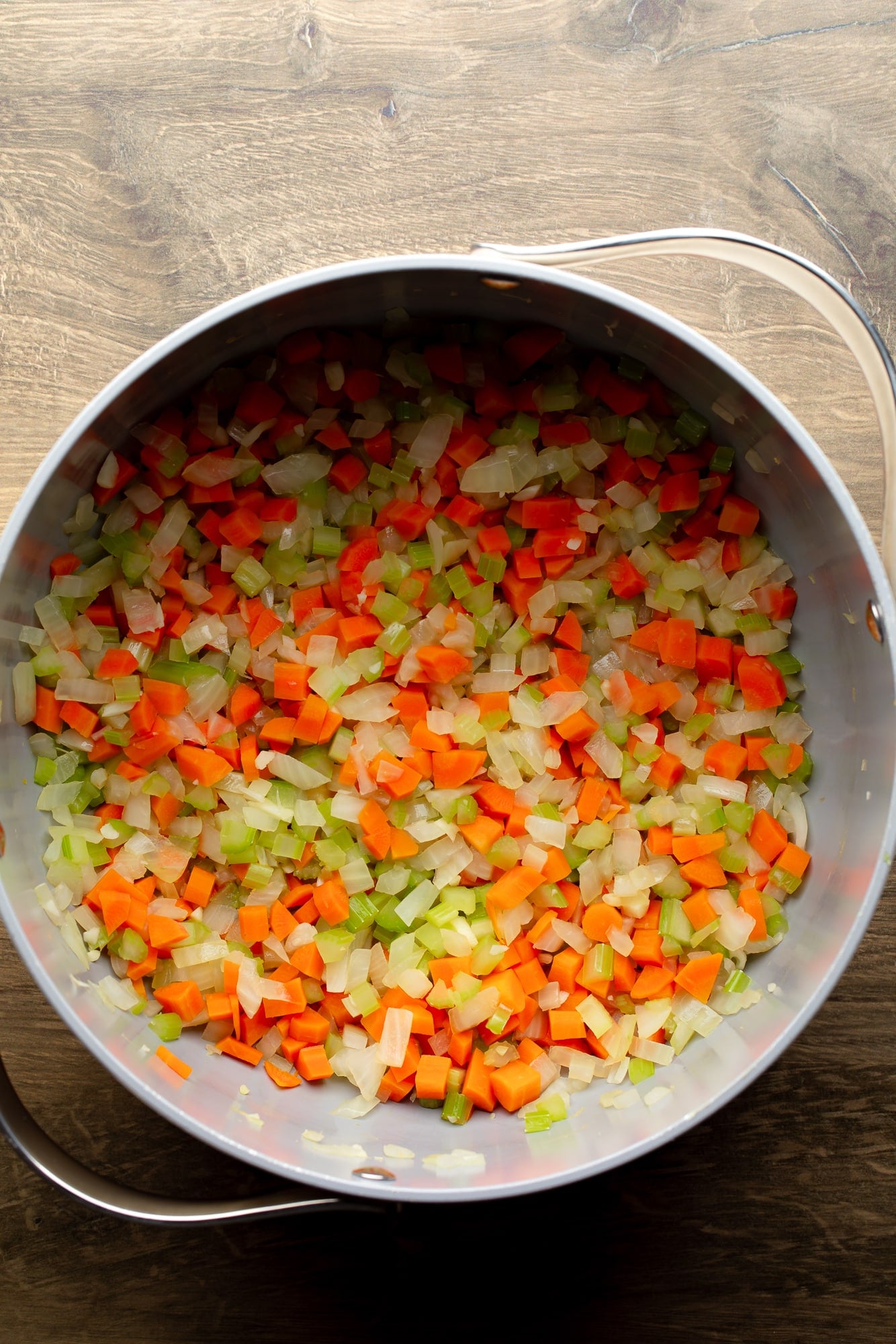 overhead view of cooked vegetables for vegan split pea soup in a large pot.