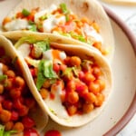 close up on 3 buffalo chickpea tacos on a plate.
