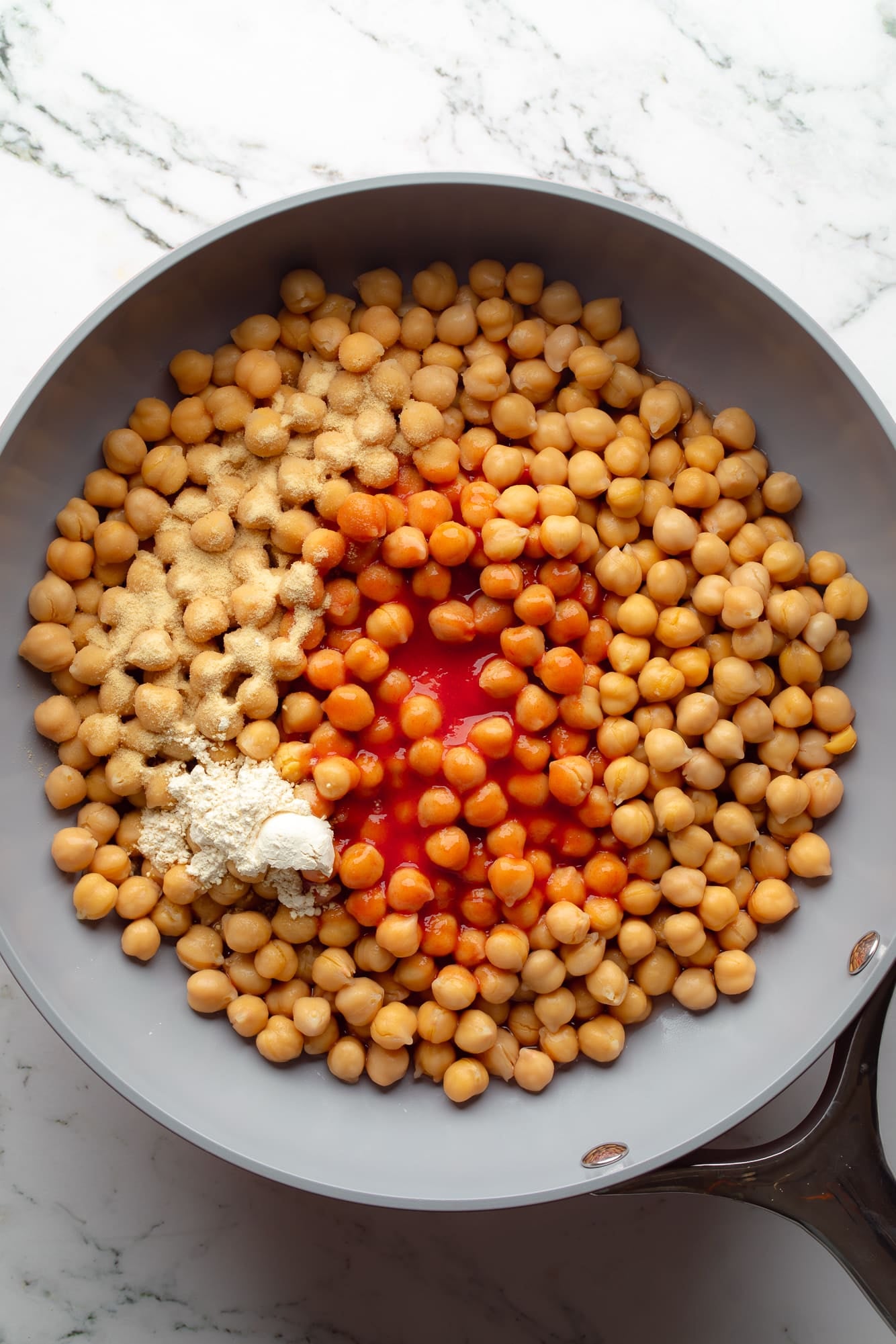 overhead view of the ingredients for buffalo chickpea tacos in a skillet.