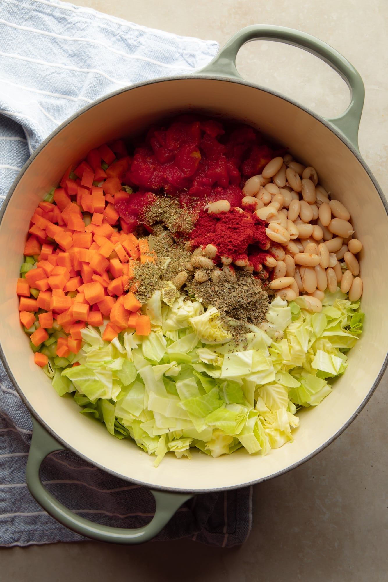 overhead view of the ingredients for vegan cabbage soup in a pot.