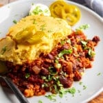 close up on a slice of chili cornbread casserole on a white plate.
