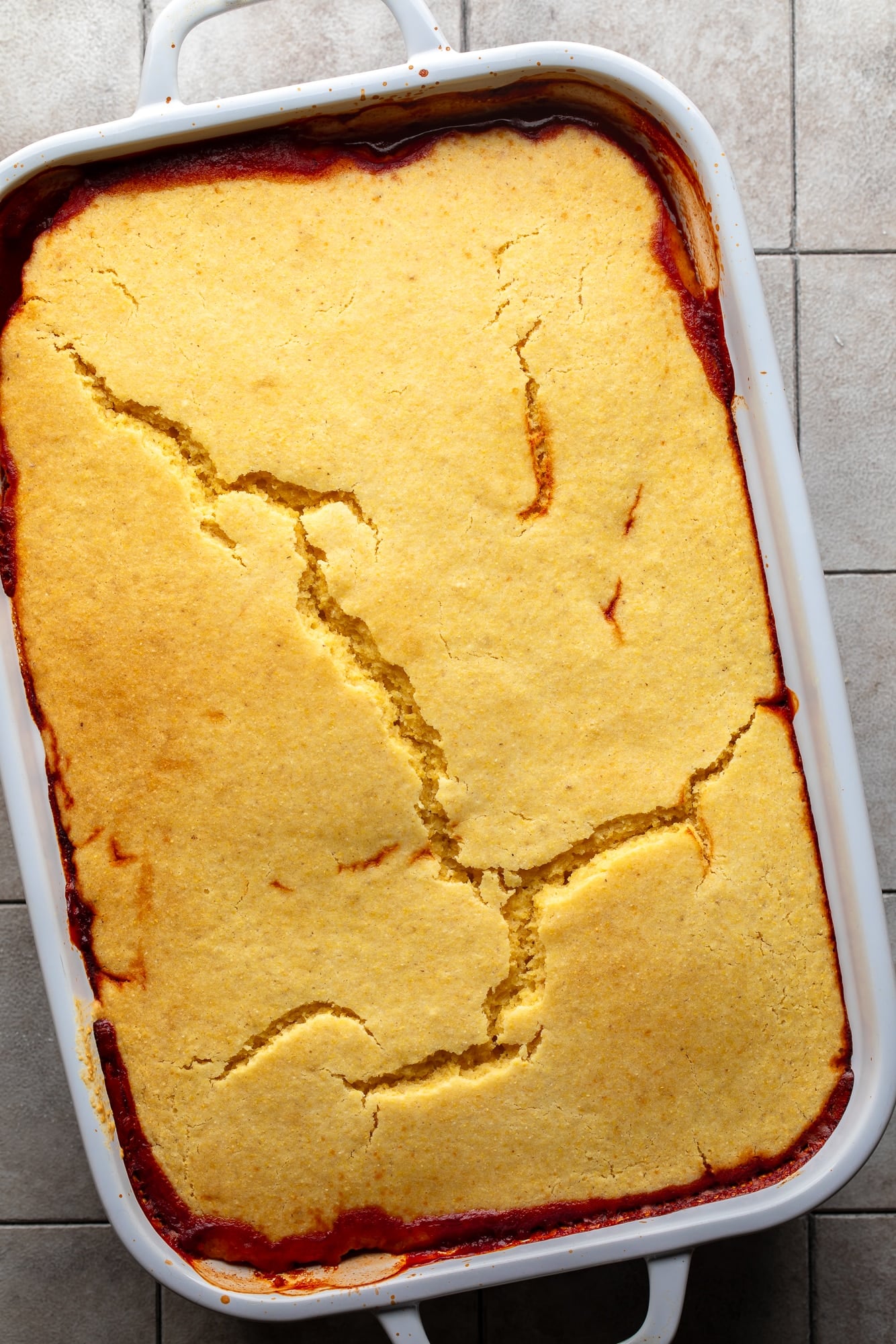 overhead view of a baked chili cornbread casserole in a white casserole dish.