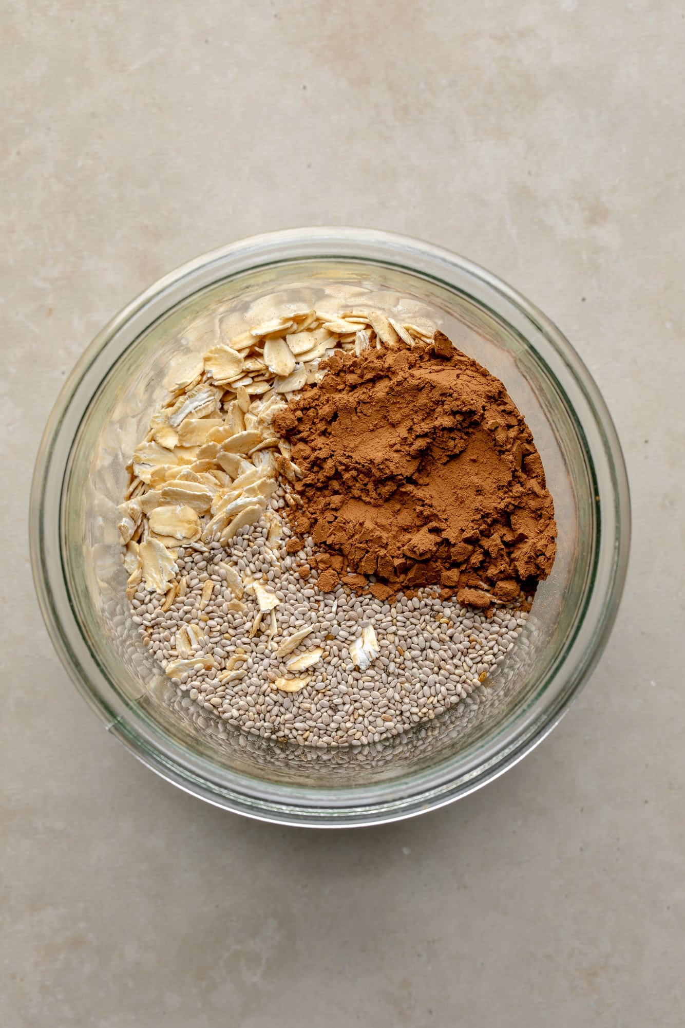 overhead view of the ingredients for vegan chocolate overnight oats in a glass jar.